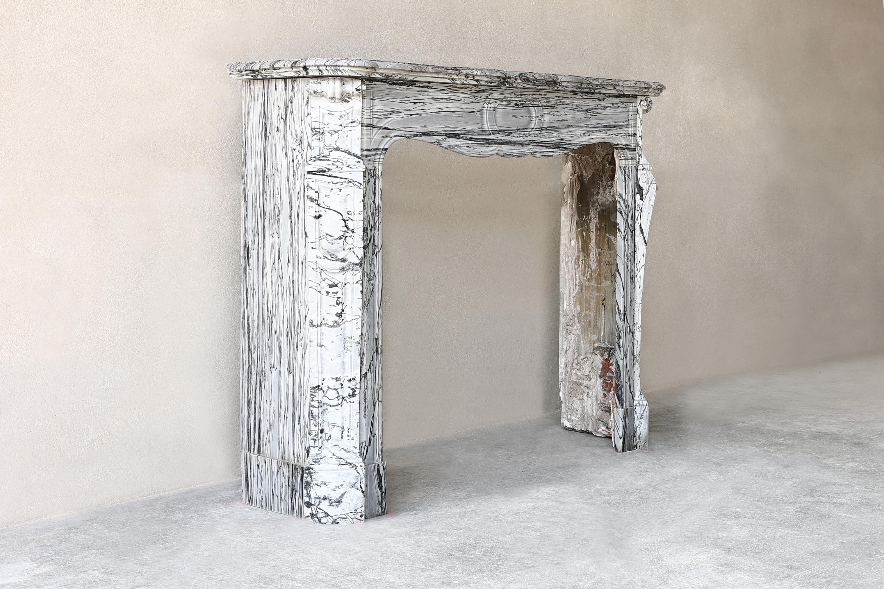 Very chic antique mantelpiece made of Bleu Fleuri marble. This fireplace is in Pompadour style and dates from the 19th century. A beautiful mantle in terms of size and appearance! 