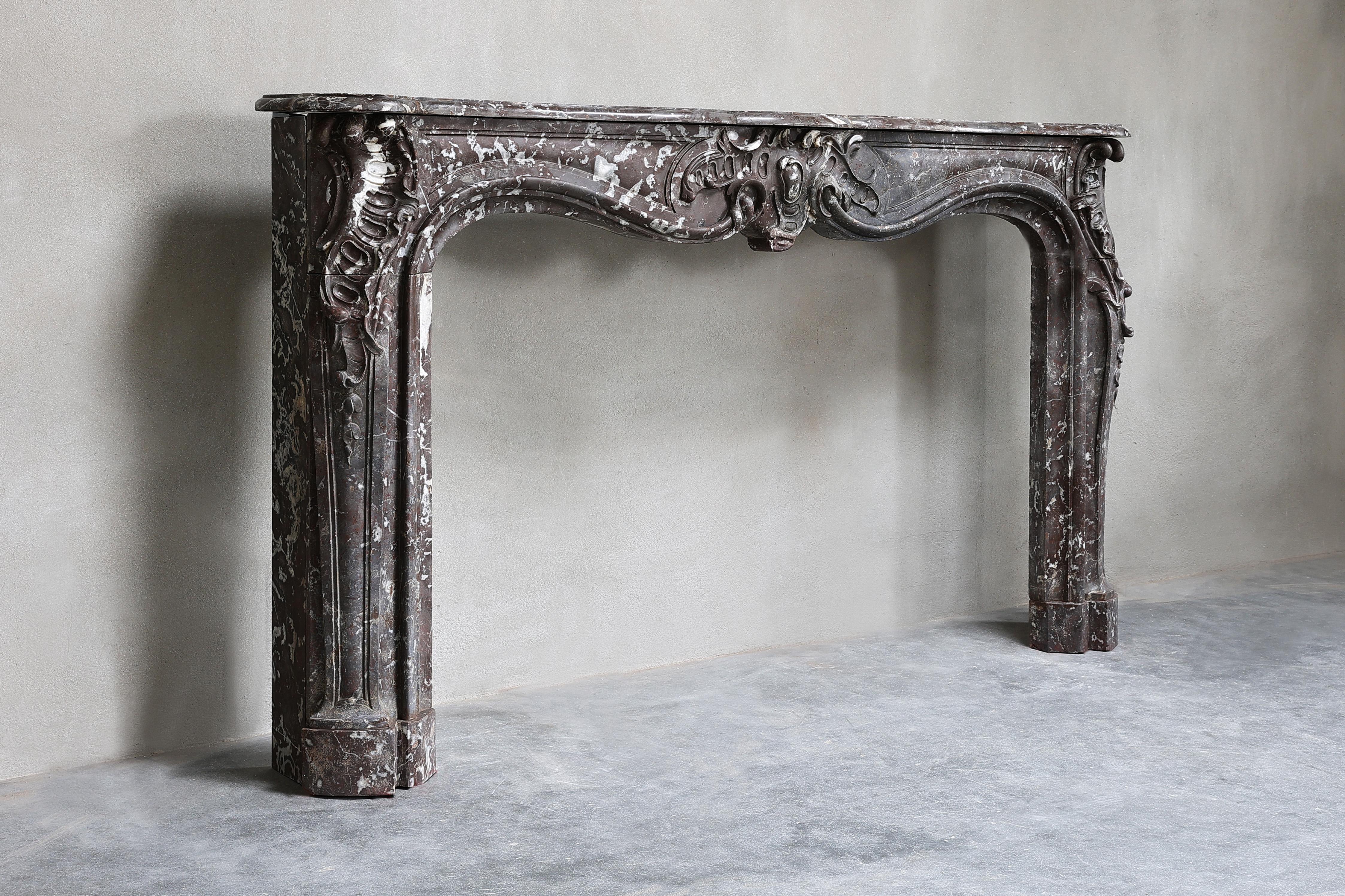 Very impressive antique marble fireplace in the style of Louis XV. The size is exceptionally large for a marble fireplace, 203 cm wide! The fireplace has a beautiful scallop in the middle and beautiful ornaments are also visible on the ends of the