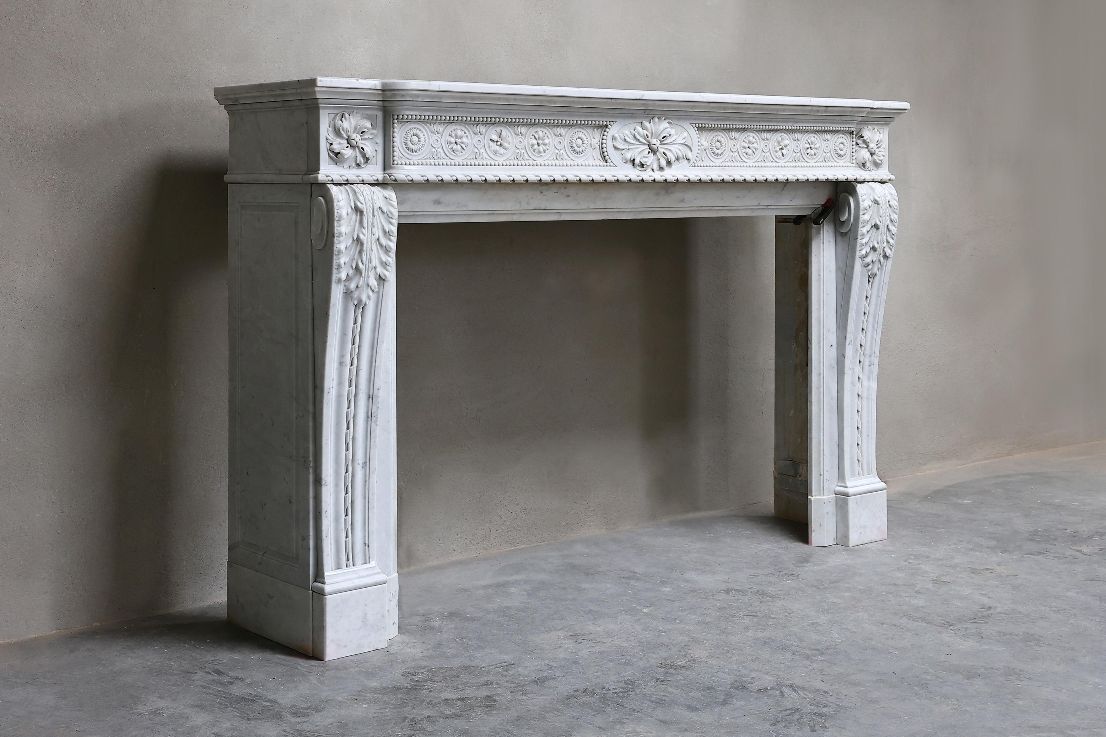 Very exclusive mantel of Carrara marble from Italy! A beautifully decorated fireplace in the style of Louis XVI with various ornaments in the front part of the fireplace and on the legs! This fireplace from the 19th century is chic and has an
