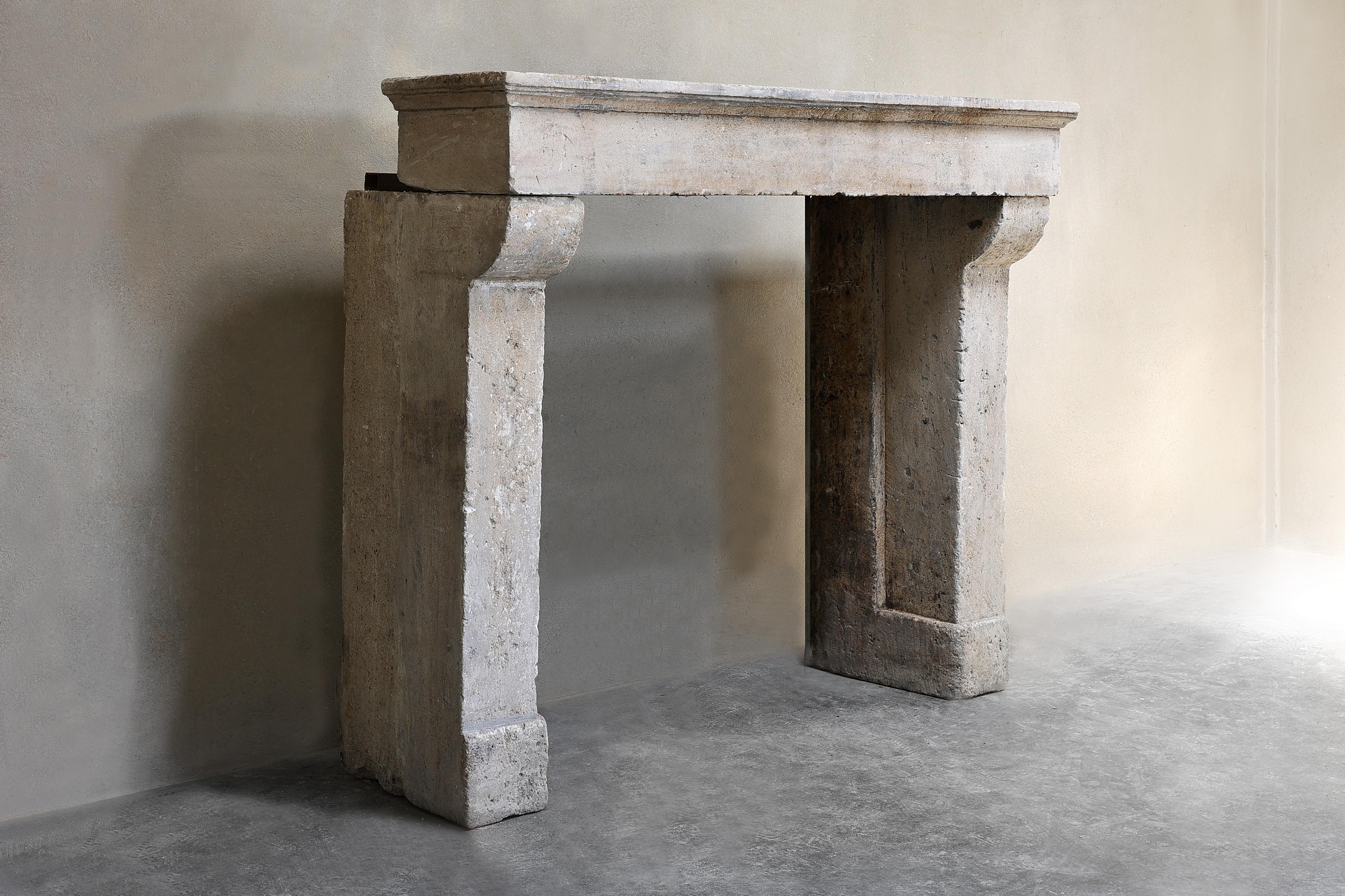 Beautiful rustic French limestone fireplace from the 19th century. This antique fireplace is in Campagnarde style and has a warm color scheme with slightly curved legs and beautiful lines in the top. The width of this fireplace is 139 cm and fits in