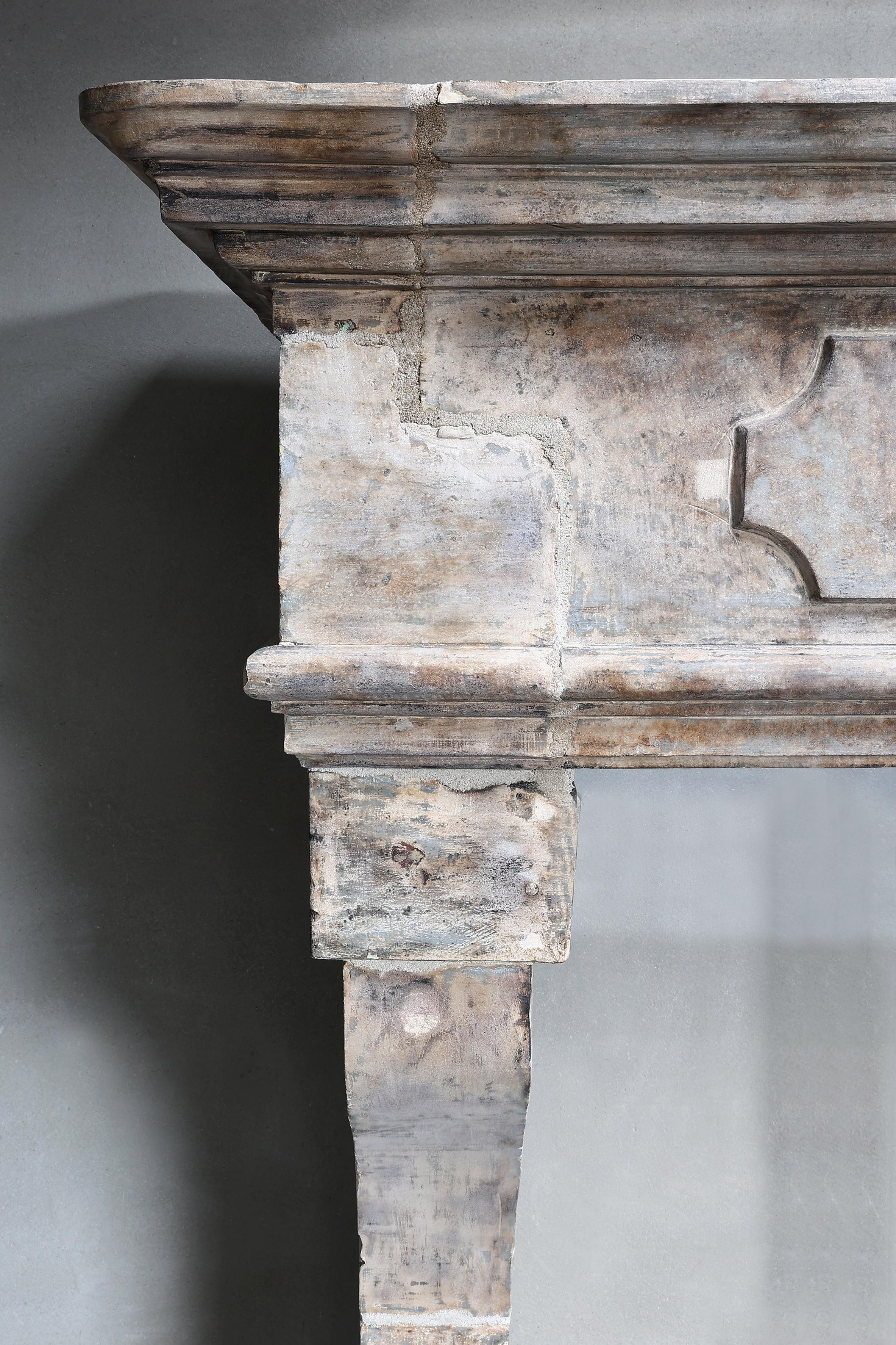 Beautiful robust castle fireplace of French limestone! This fireplace from the 19th century has beautiful ornaments in the front part and has slightly curved legs and a wide top. It is a fireplace in the style of Louis XIII and has a width of 235 cm!