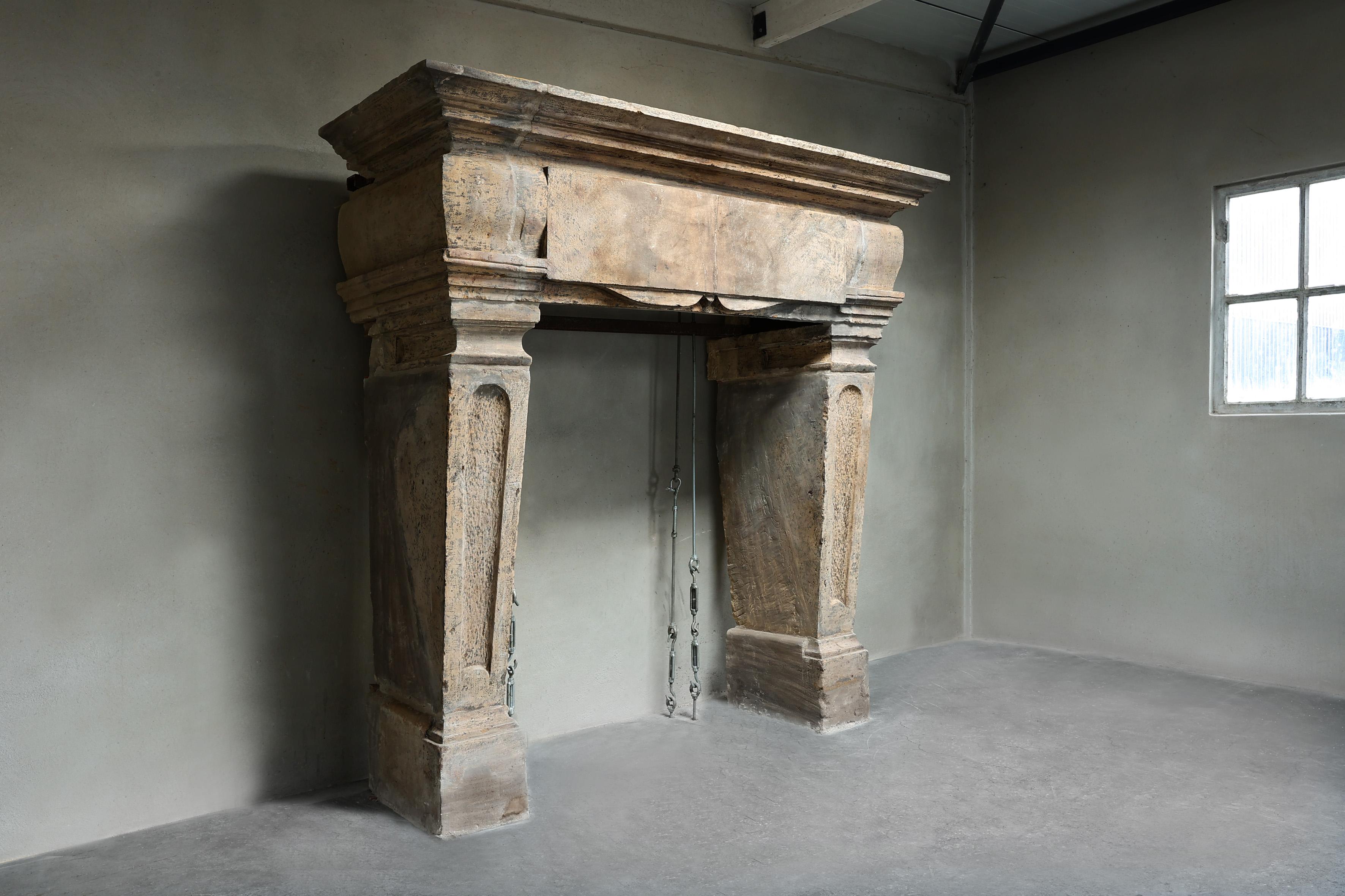 Very imposing castle fireplace of French limestone from the 19th century. This antique mantle has a width of 210 cm and is in the style of Louis XIII. A fireplace with beautiful decorations and lines in the top and on the legs.
Be aware that the
