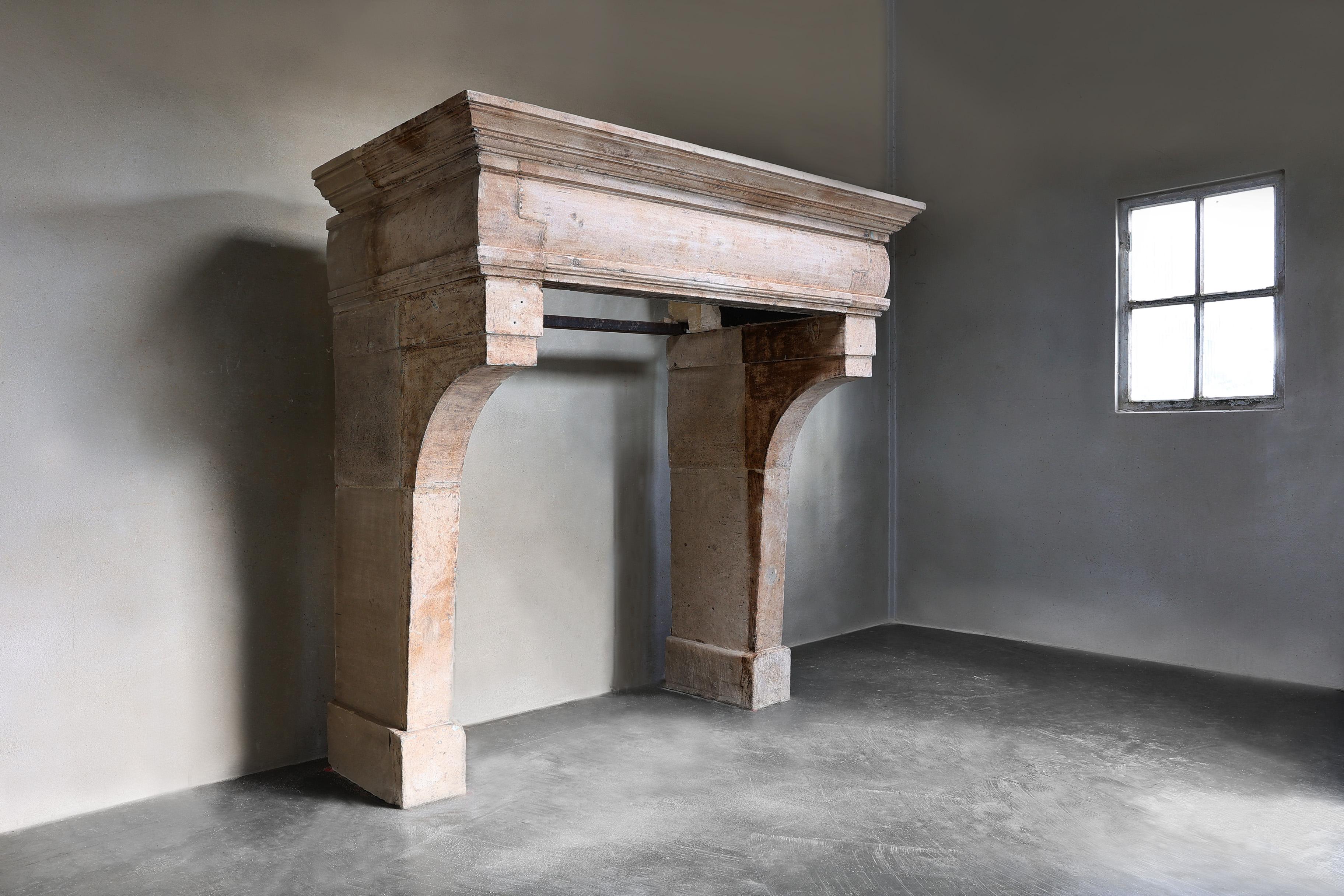 Beautiful antique fireplace made of French limestone from the 19th century in the style of Louis XIII.  This French antique fireplace mantle has a wide front section with beautiful obelisque legs and warm colors!