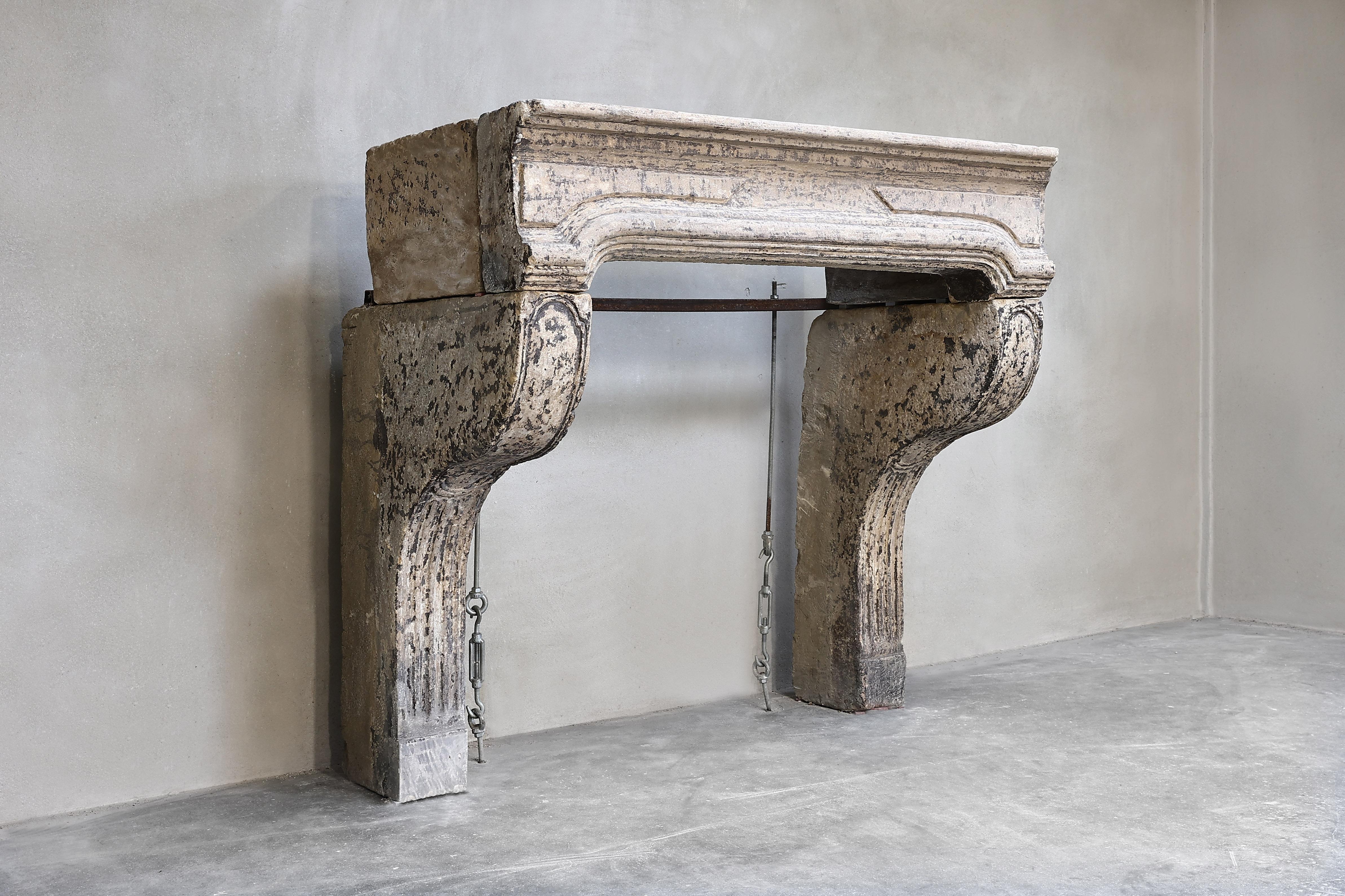 Beautiful antique fireplace in French limestone in the style of Louis XIV from the 19th century. An very authentic fireplace with beautiful lines and hand-cutouts. The patina provides an authentic look and feel! A nice compact fireplace with history!