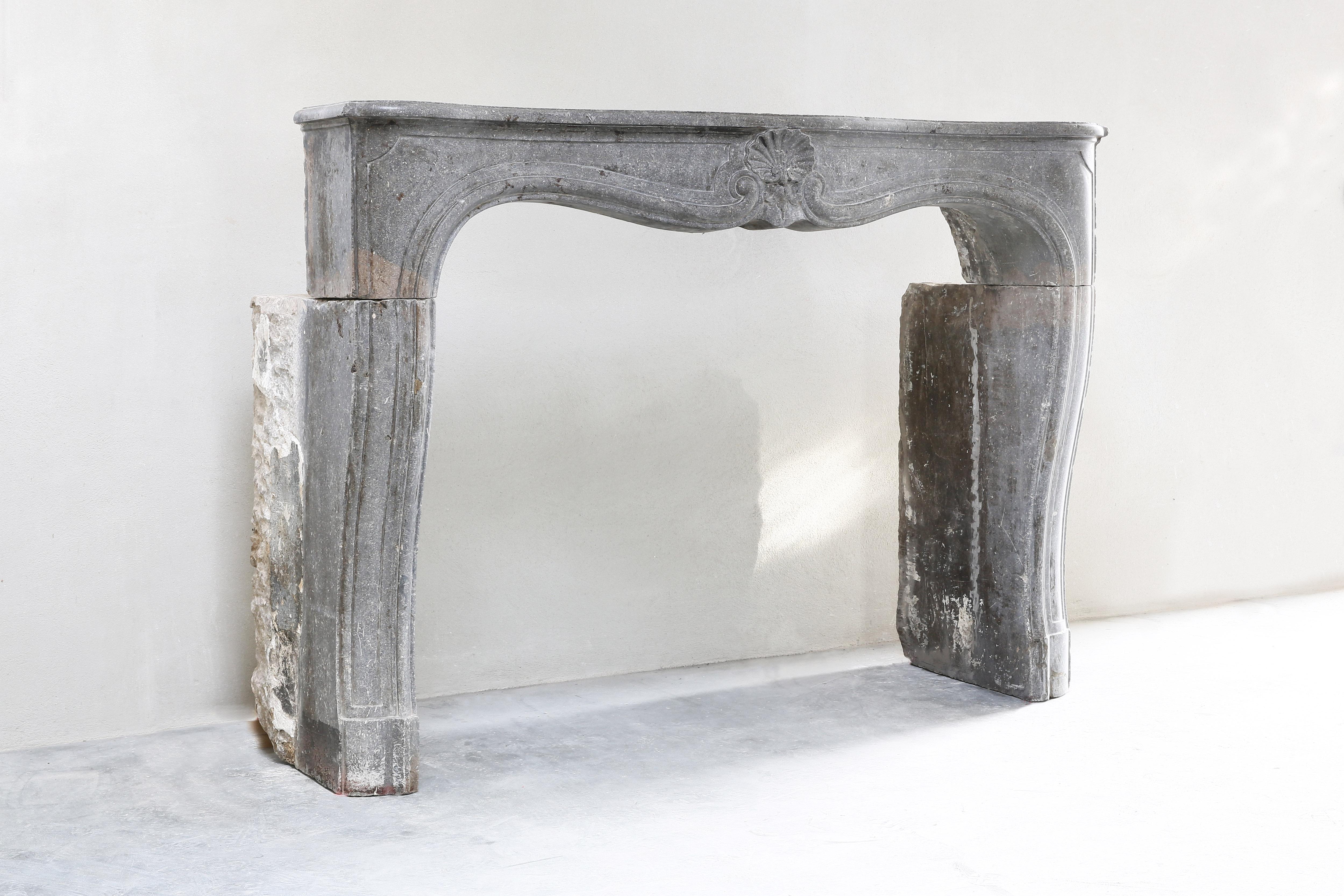 Beautiful antique fireplace from gray marble stone of the 19th century. This fireplace is in the style of Louis XV and has a shell in the middle. A beautiful decorative fireplace with beautiful lines. A fireplace that fits in many interiors in terms