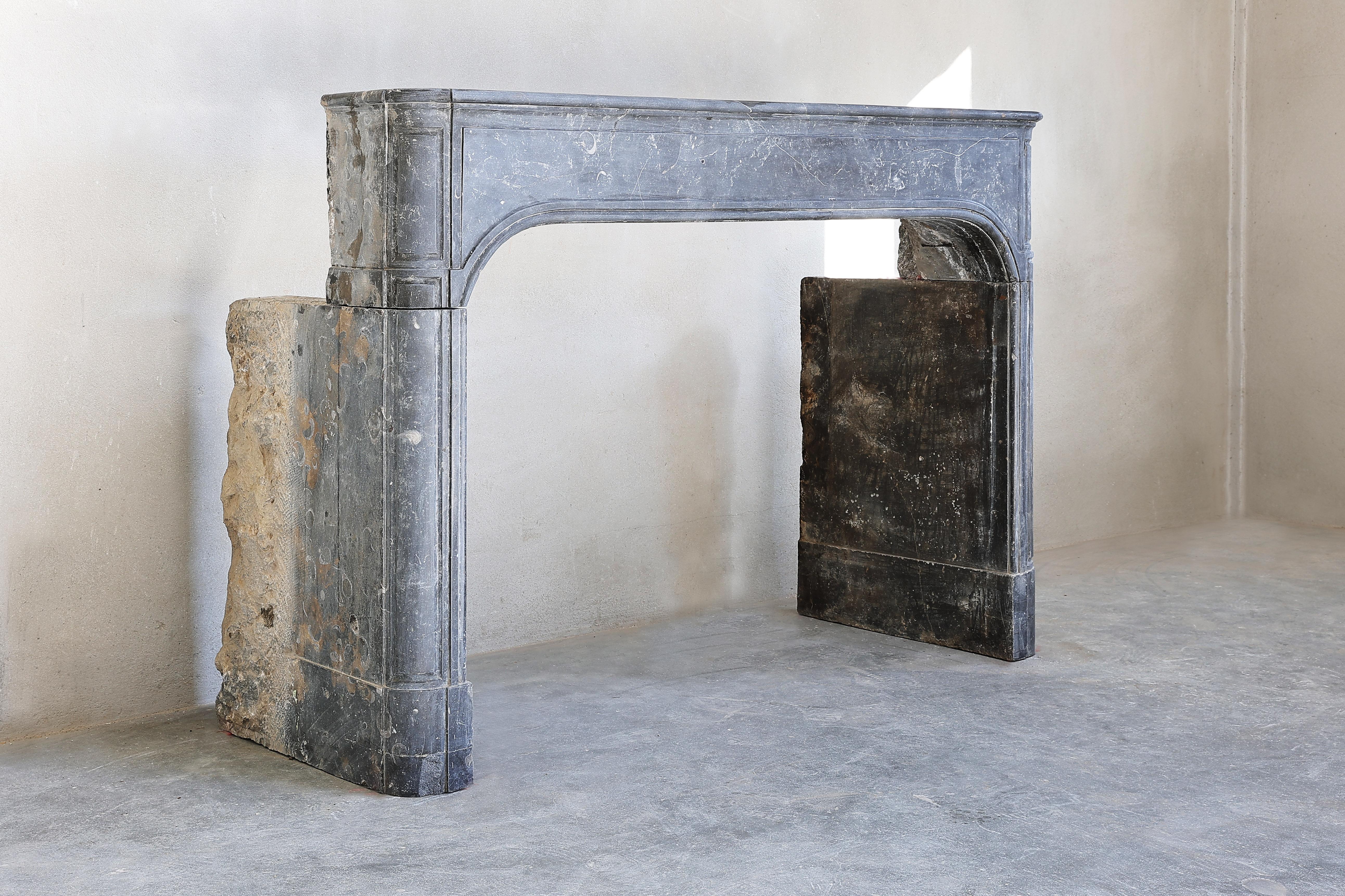 Unique grey marble stone fireplace in the style of Louis XIV. A very nice marble stone mantle with fossils and light veins. This fireplace dates from the 19th century and is in good condition. A quiet fireplace with beautiful lines.