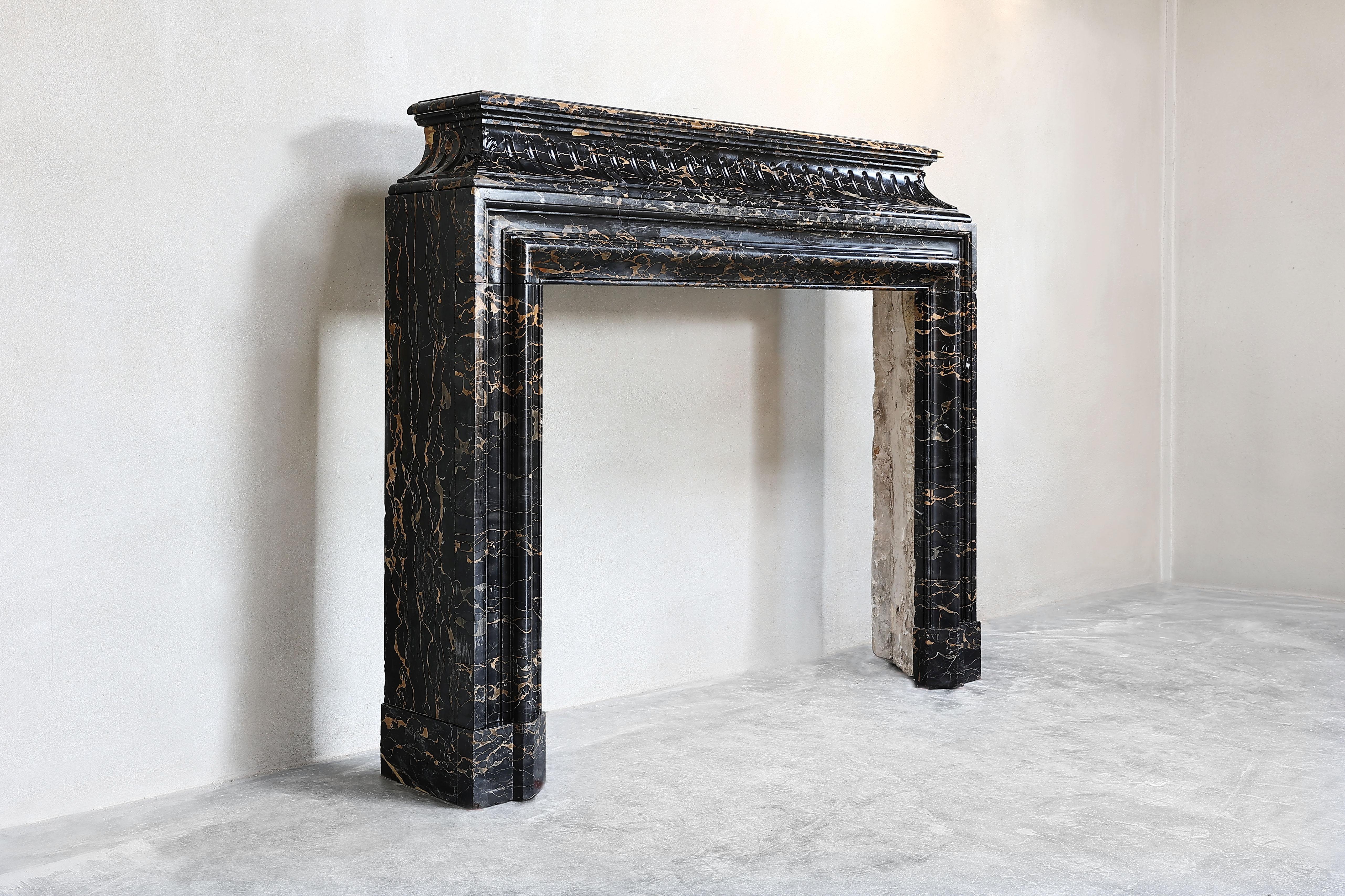 Beautiful unique fireplace of Portoro marble. Portoro marble has its origin in Italy and is a very nice warm marble of dark brown/black with beautiful flamed veins! This antique fireplace dates from the 19th century and is in the style of Louis XVI.
