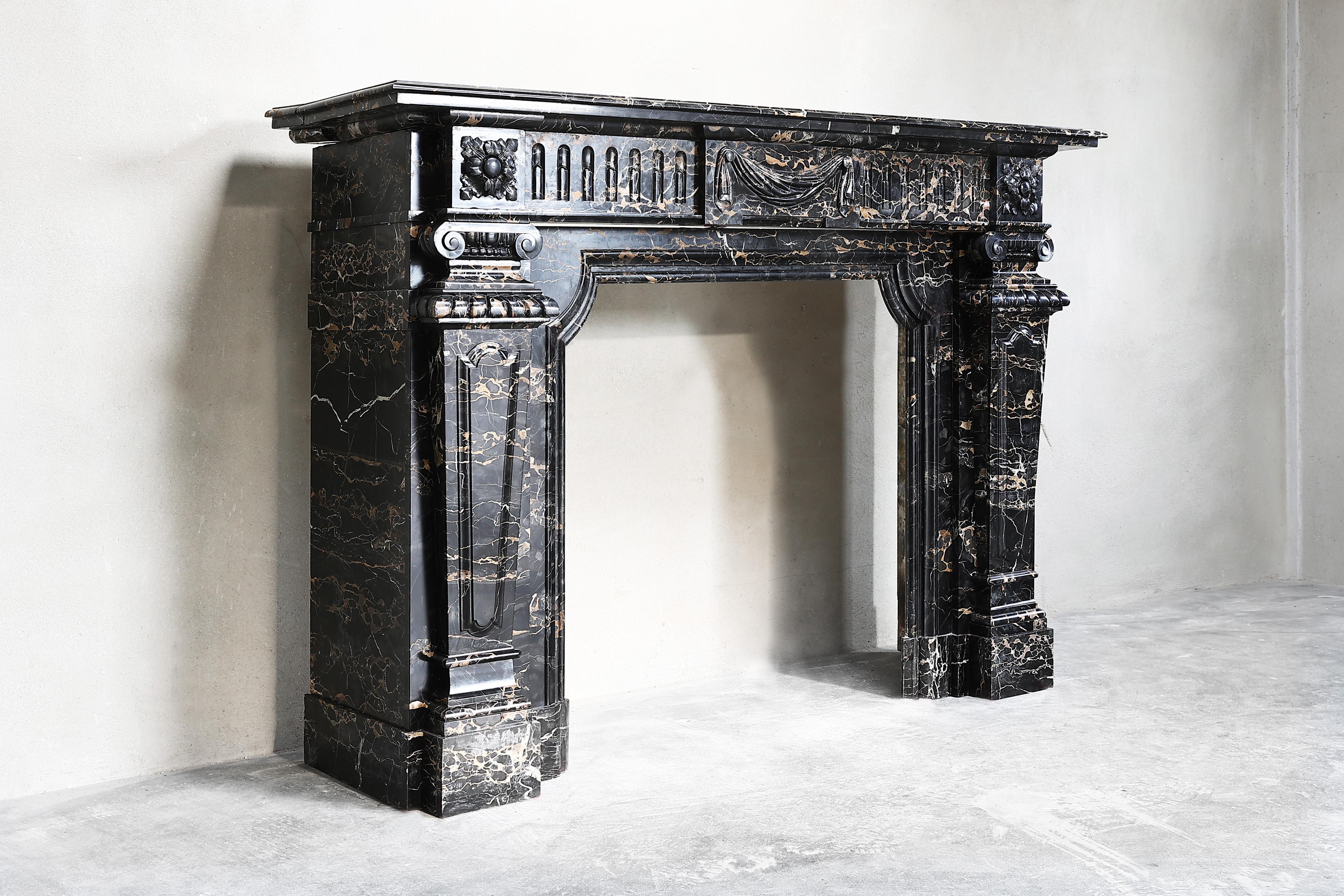 Very special exclusive fireplace of Portoro marble from the end of the 19th century. This antique mantle is in the style of Louis XVI and is particularly decorated with various ornaments and decorations. It is unique to report that this fireplace is