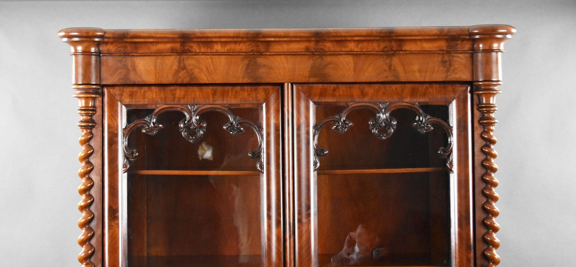 For sale is a good quality 19th century Biedermeier flame mahogany bookcase. Having fine veneers throughout, the bookcase has two glazed doors flanked by turned columns. Opening to four adjustable shelves with a drawer below, the bookcase is in