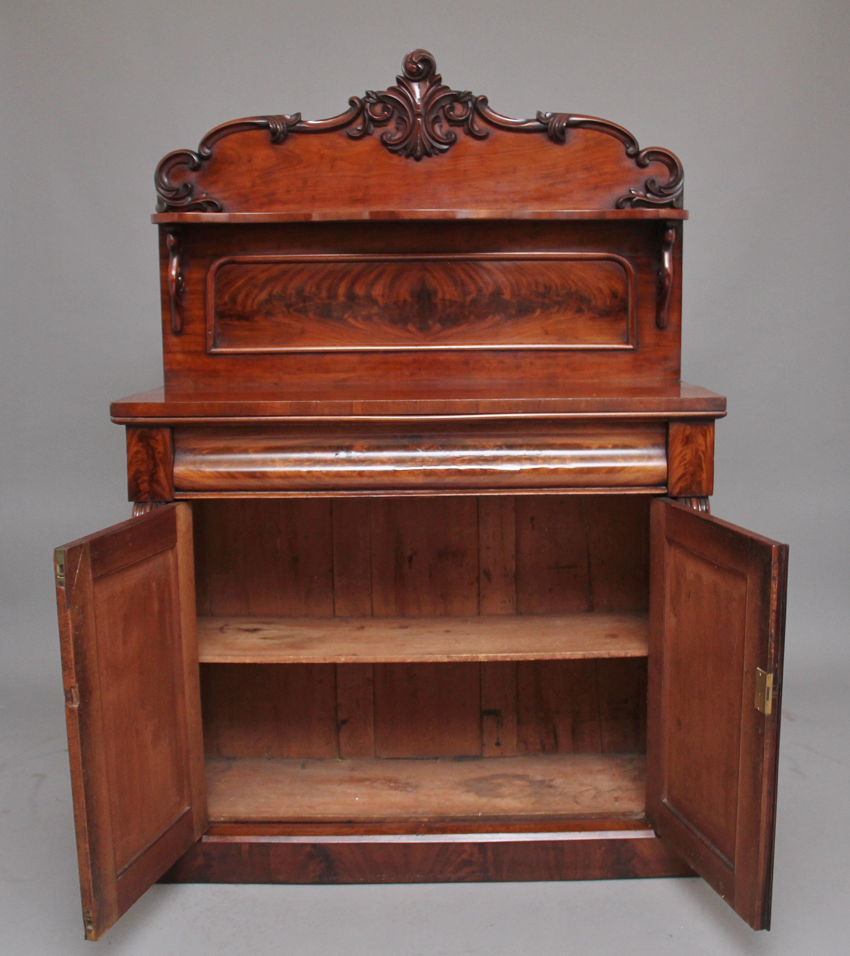 19th century flame mahogany chiffonier cabinet, having a shaped and moulded carved scrolled pediment above a shaped shelf with a flame mahogany panel below, the base having single mahogany lined frieze drawer above two flame mahogany paneled doors
