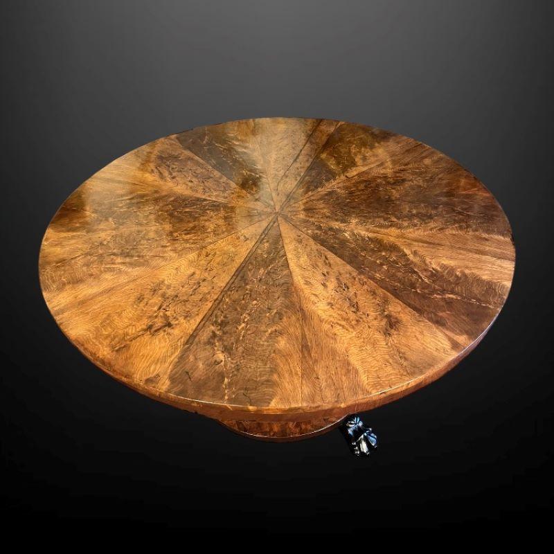 A superb flame mahogany circular center table circa 1820

This segmented Regency tilt-top breakfast/tea table stands on a faceted column supported by a round platform base with three paw feet.

A very attractive piece.