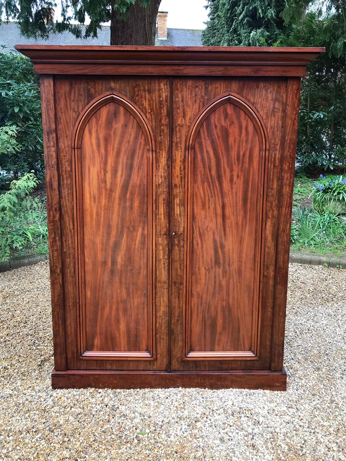 19th century flame mahogany compactum wardrobe (Gentleman's Wardrobe) with two flamed paneled doors. The original interior has hanging space on the left with a drawer below, on the right hand side there are six sliding trays with three oak lined