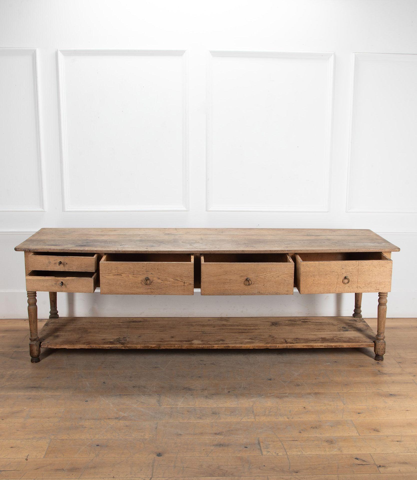 19th Century Flemish sturdy oak draper's table on turned legs.
With three large drawers and two small drawers with keys that serve as drawer pulls only.
The four plank top has four coin slots over the small drawers. Signs of use and age along
