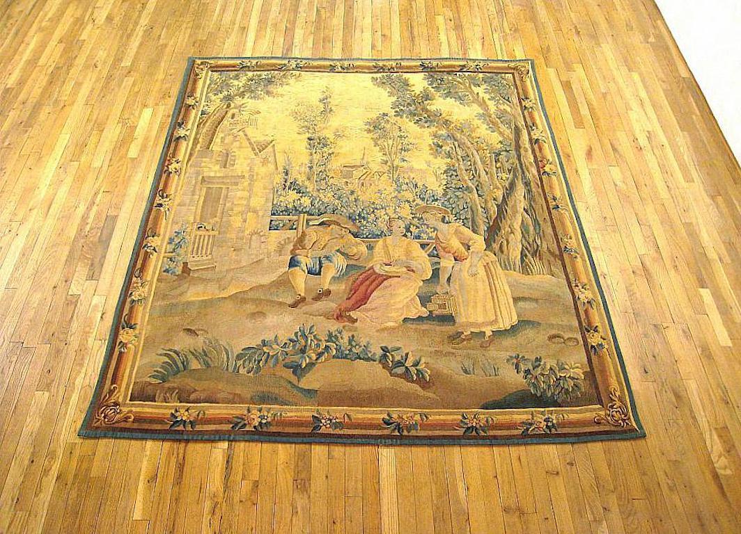 A Flemish rustic tapestry from the 19th century, envisioning a noblewoman seated at center holding a plate of food, with another woman standing to her right with an empty bird cage, and a man seated to her left feeding a bird. This tranquil scene