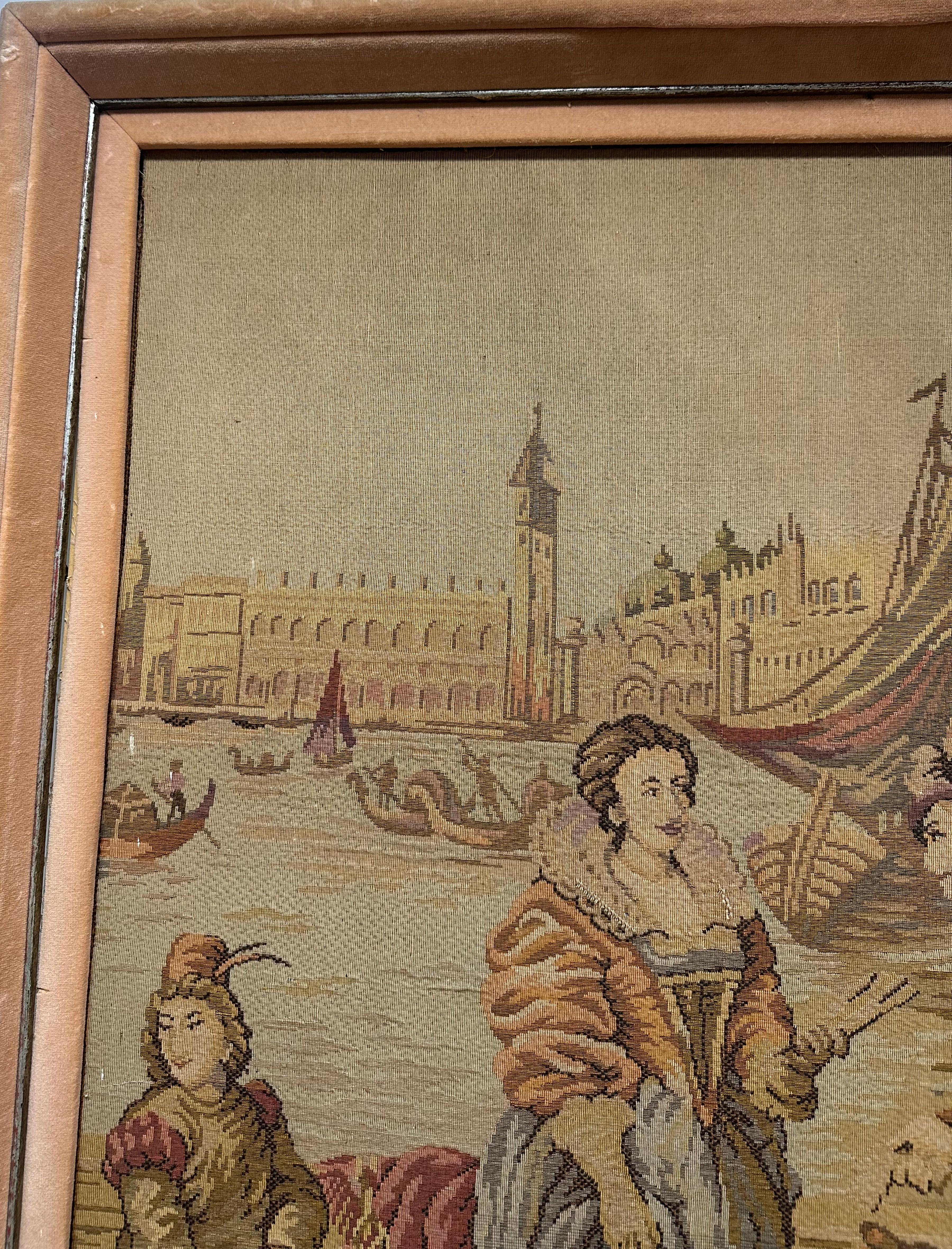 Une belle tapisserie jacquard encadrée d'époque. Cette scène de style Renaissance montre un homme et une femme portant des vêtements historiques élaborés sur une terrasse au bord de l'eau, avec des gondoles, le Grand Canal de Venise et un galion à