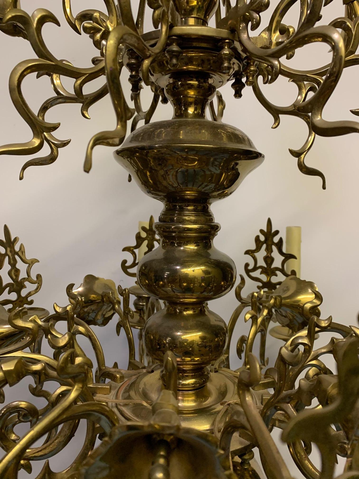Flemmish brass eight light 19th century chandelier. This Baroque style eight light chandelier has a beautiful golden patina and has a floral motif.