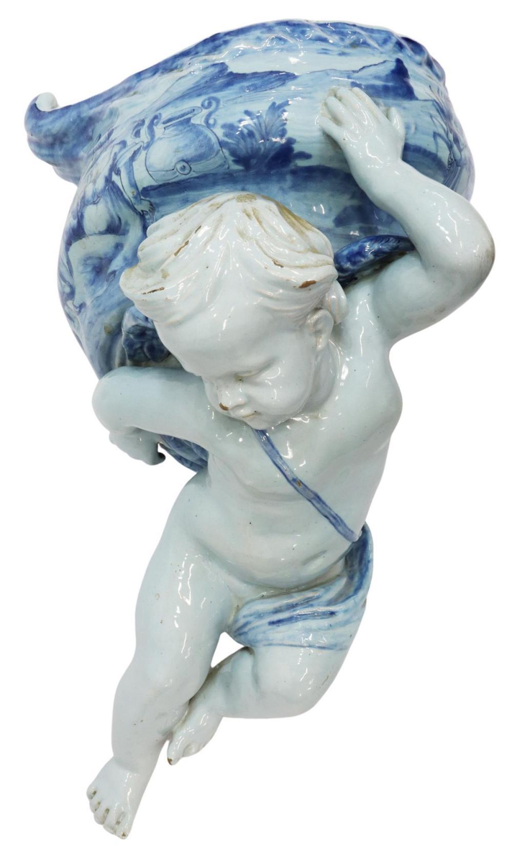 Stunning Italian blue and white majolica wall-mounted jardiniere, by Ulisse Cantagalli, Florence, 19th c., modeled as a winged putto, supporting a shell-form vessel, painted with scene of woman and cherubs, cockerel/ rooster mark at interior.