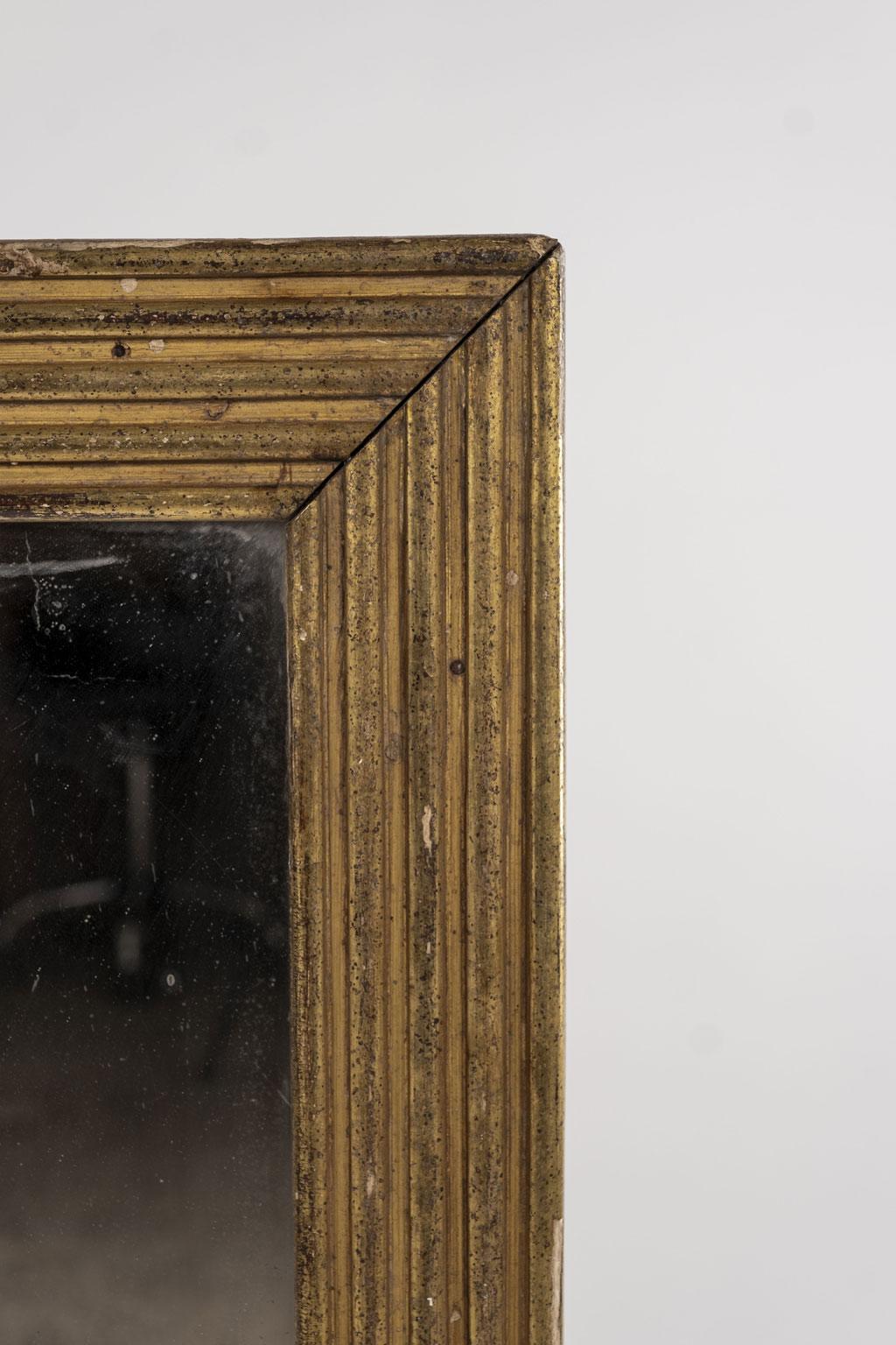 19th century fluted giltwood mirror frame surrounding old mirror plate with minor losses to silvered reverse.