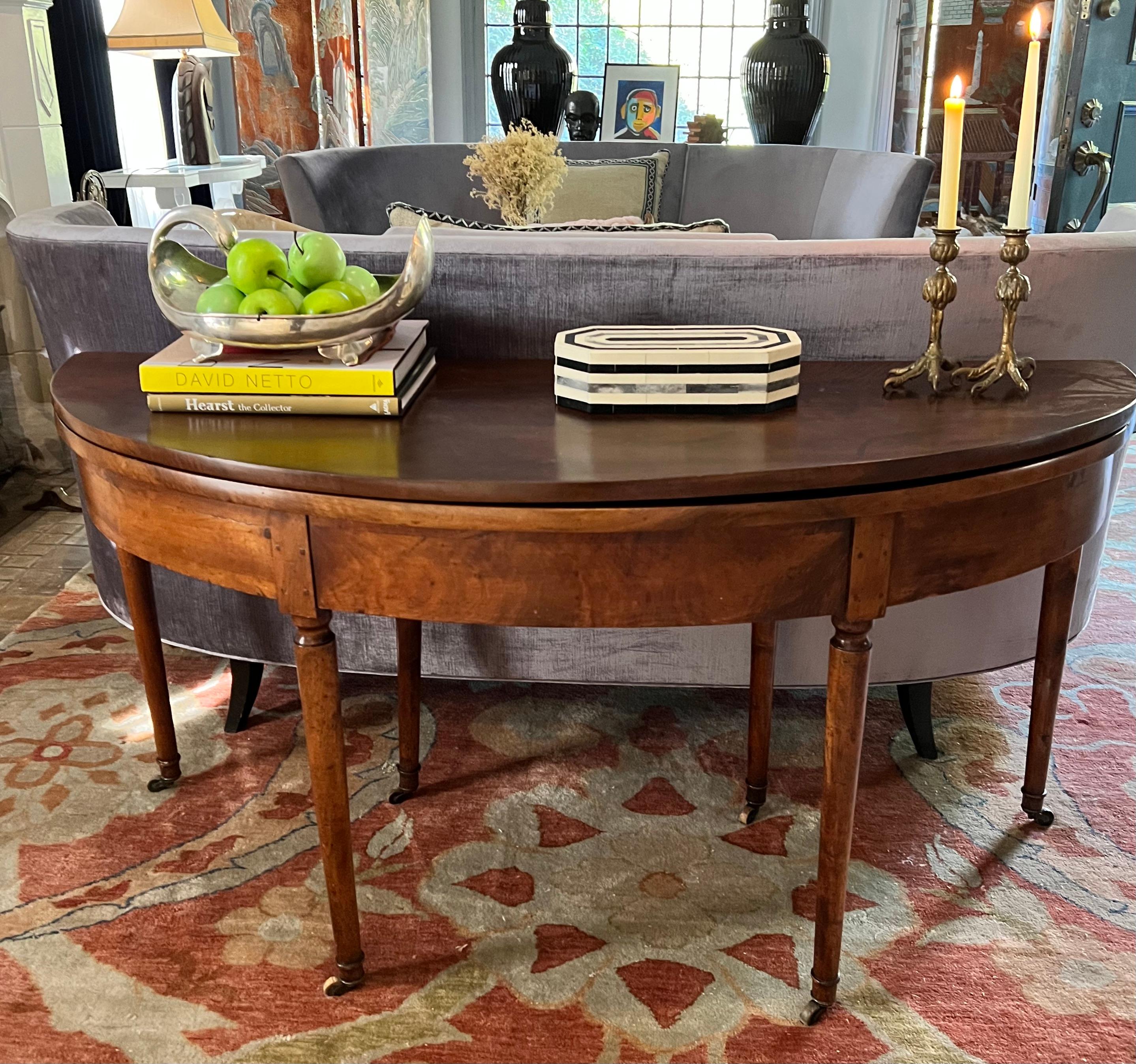 A stunning Early 19th Century Fruitwood Fold over dining or console table.  The piece retains all of its original hardware, hinges, casters, etc. and has beautifully crafted joints and dovetails throughout.  

A convenient drawers pulls out to hold