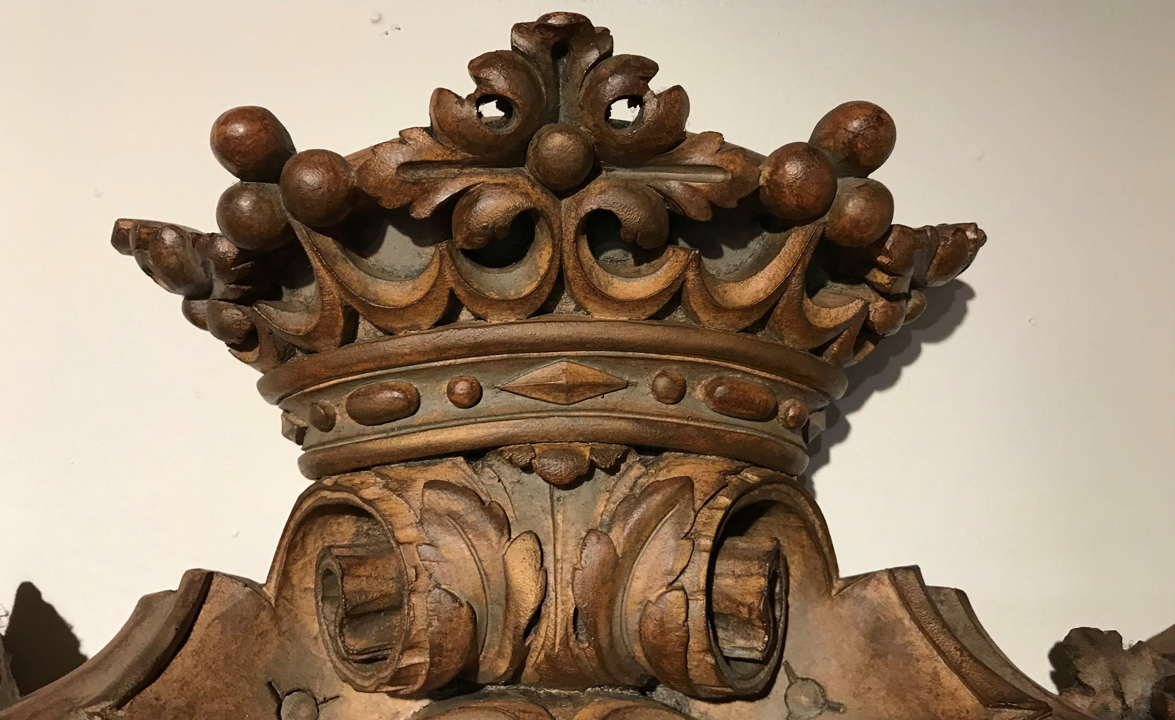 A nicely detailed carved crest with a crown at the top and the letter “M” in the central panel, constructed from wood and composition, European in origin, dating to the 19th century, with great overall patina and minimal imperfections and losses.