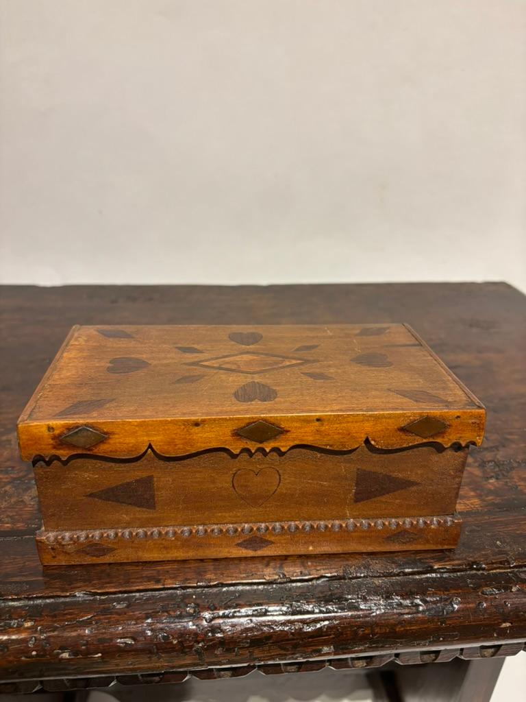 Boîte d'art populaire américain du 19e siècle, décorée de cœurs, de diamants, de triangles et de boucliers incrustés. Probablement fabriquée par un marin, cette jolie petite boîte était probablement un cadeau de Saint-Valentin ou un souvenir offert