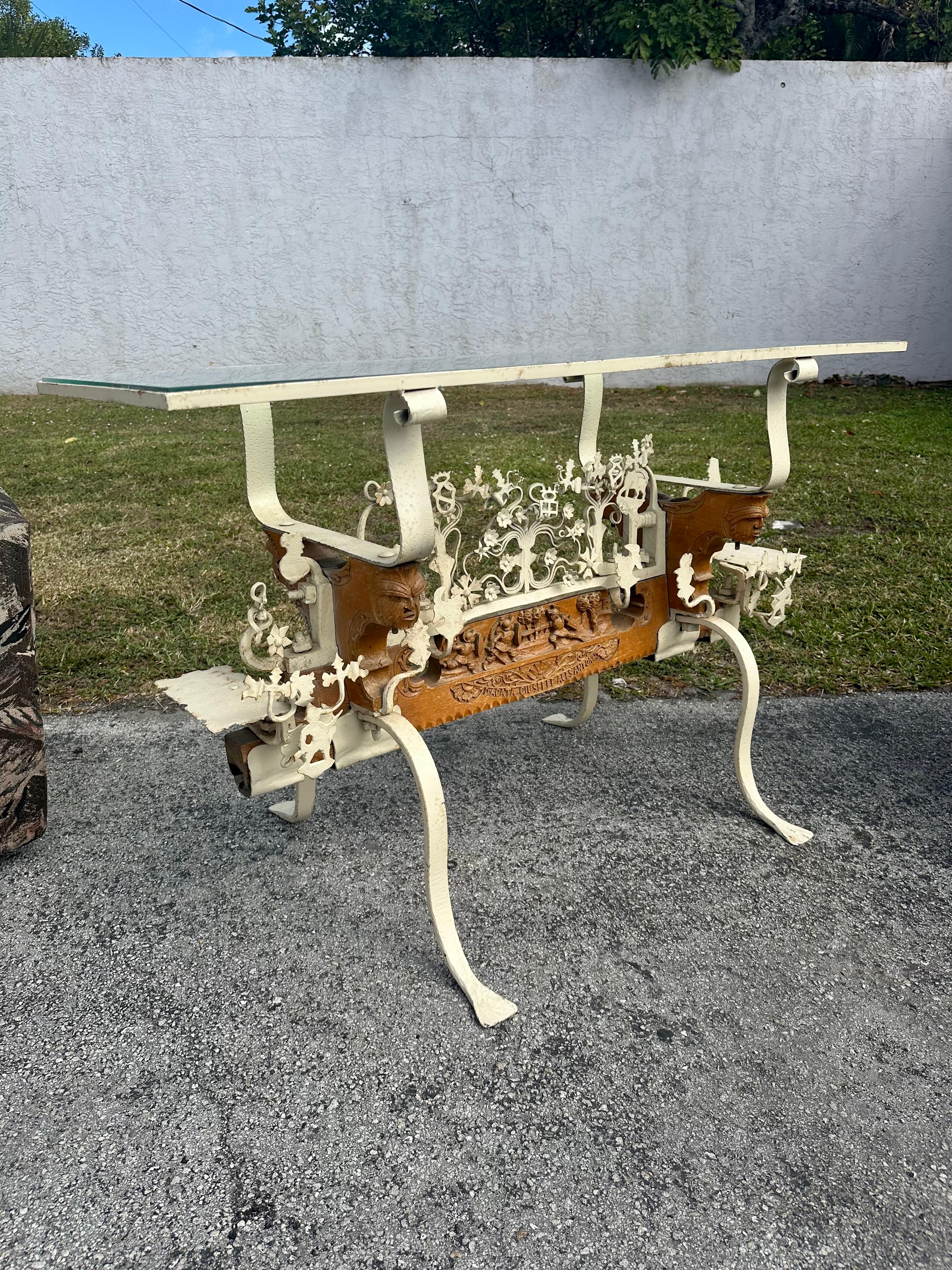 Indulge in the timeless elegance of this exquisite hand crafted folk art table, dating back to the early 19th Century. Crafted with meticulous attention to detail, the versatile glass top table showcases a stunning hand crafted carved wood and