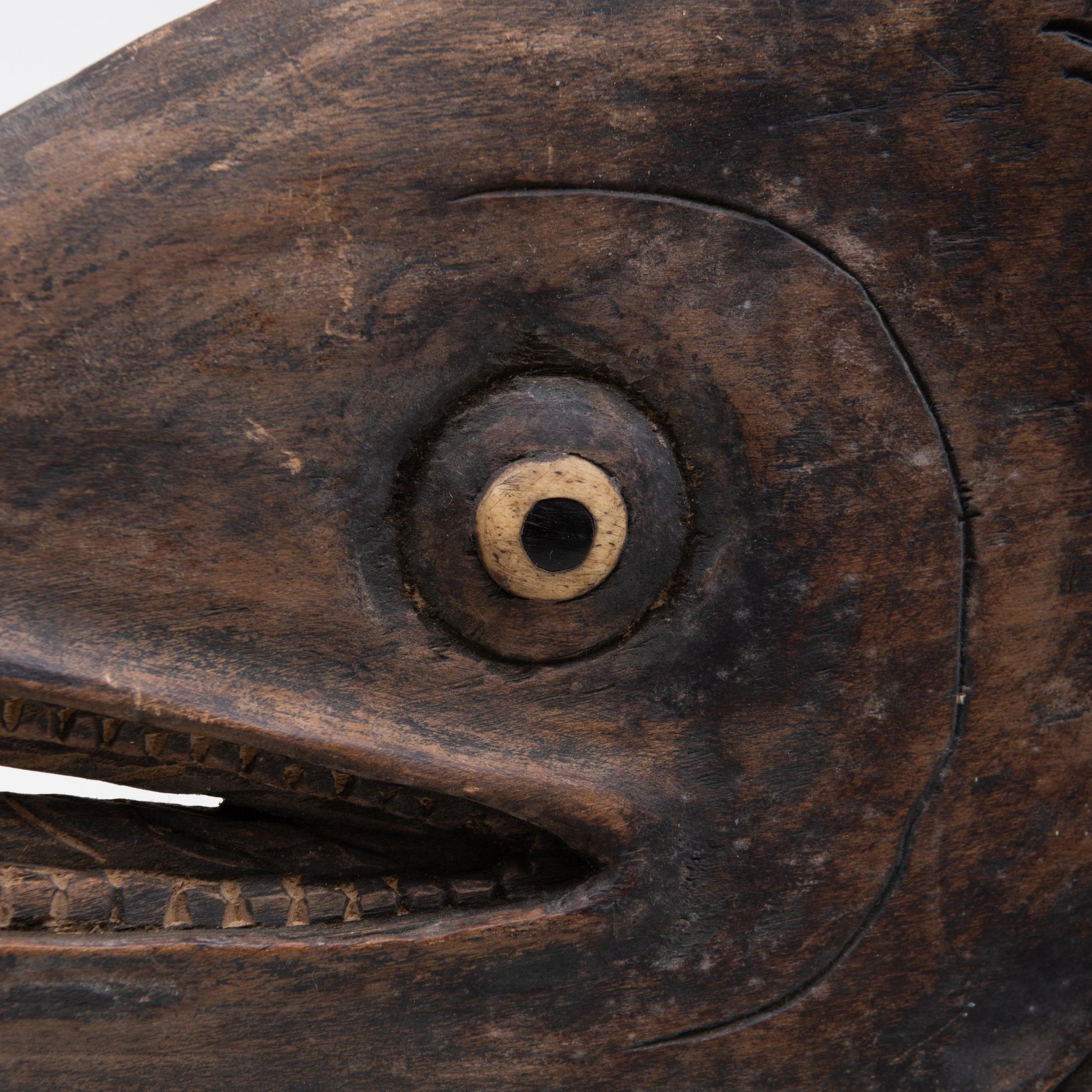 A finely hand carved wood Japanese trade sign for a fish vendor, equally detailed on both sides, with undulating, articulated surface and inlaid bone eyes. 
May be mounted on a wall horizontally or vertically, or hung from a bracket to appreciate