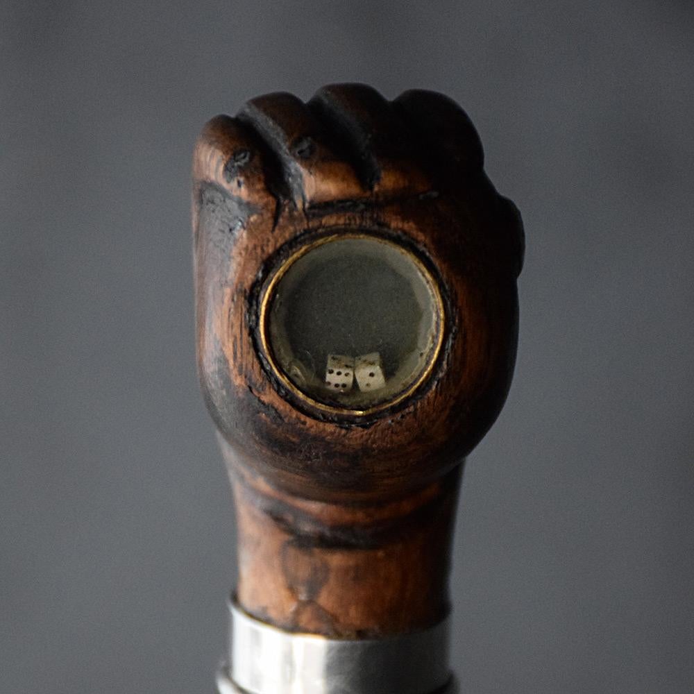 19th Century Folk-art gentleman’s dice walking cane 
We are proud to offer an unusual English folk art example of a late 19th century gentleman’s walking cane. This single piece of carved wood with hand grasping a ball, containing a pair of