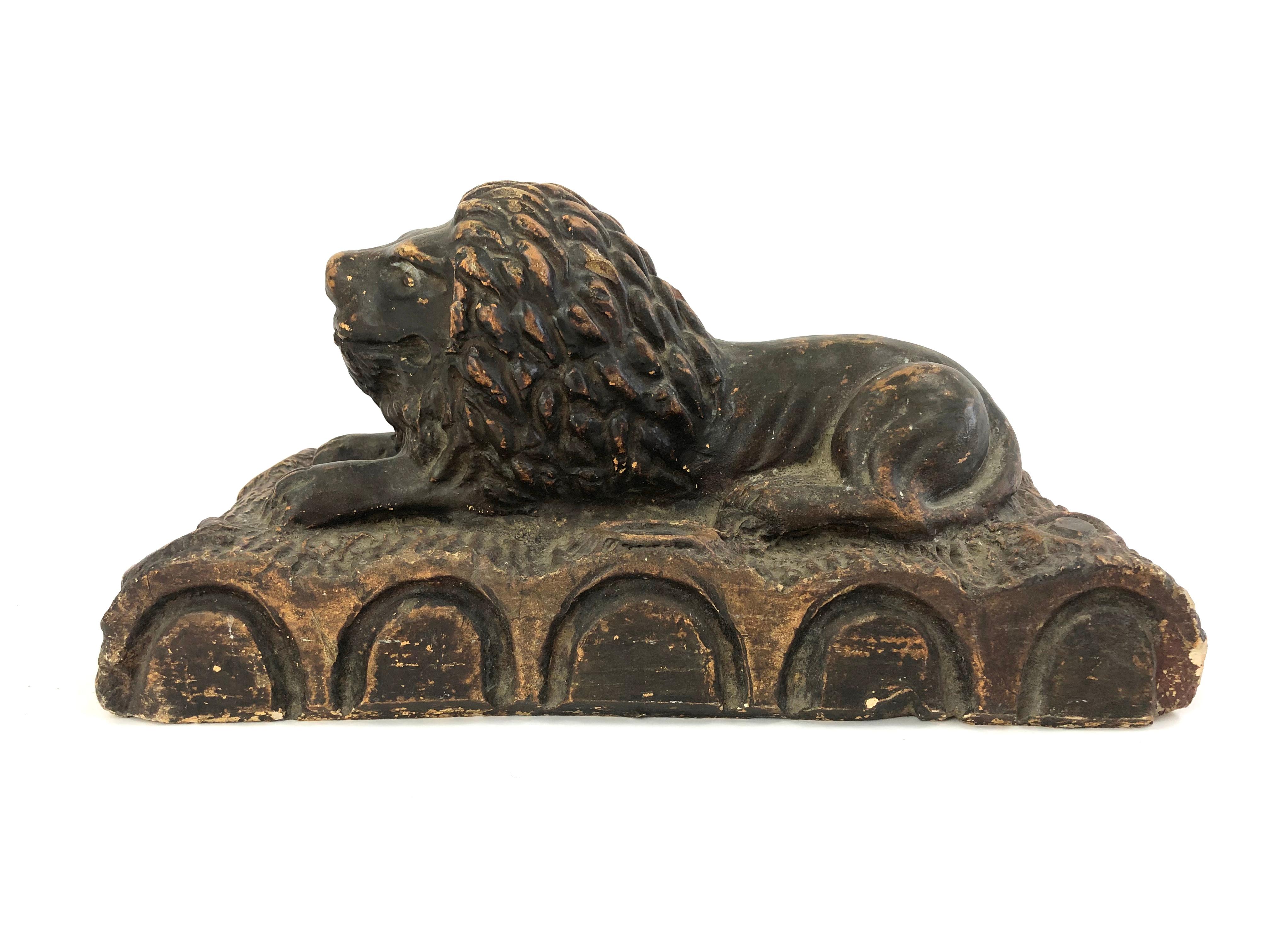 A 19th century Folk Art pottery sculpture of a recumbent, regal lion, resting on a row of boldly modeled logs. Wonderful scale and character.