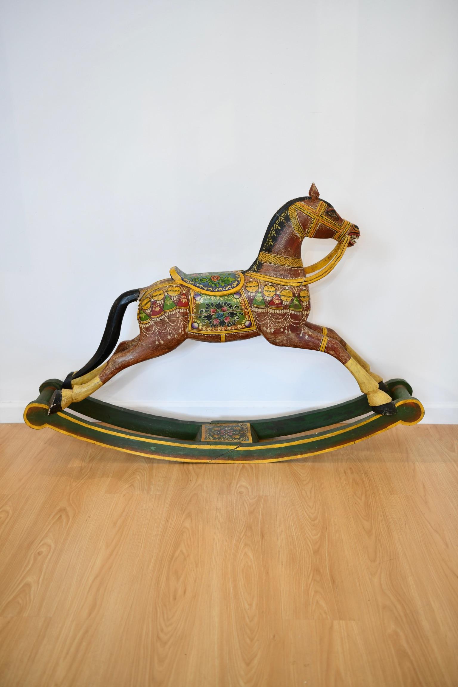 Antique Folk Art painted and decorated rocking horse. In antique condition with splits and repairs, pictured. Dimensions: 37.5