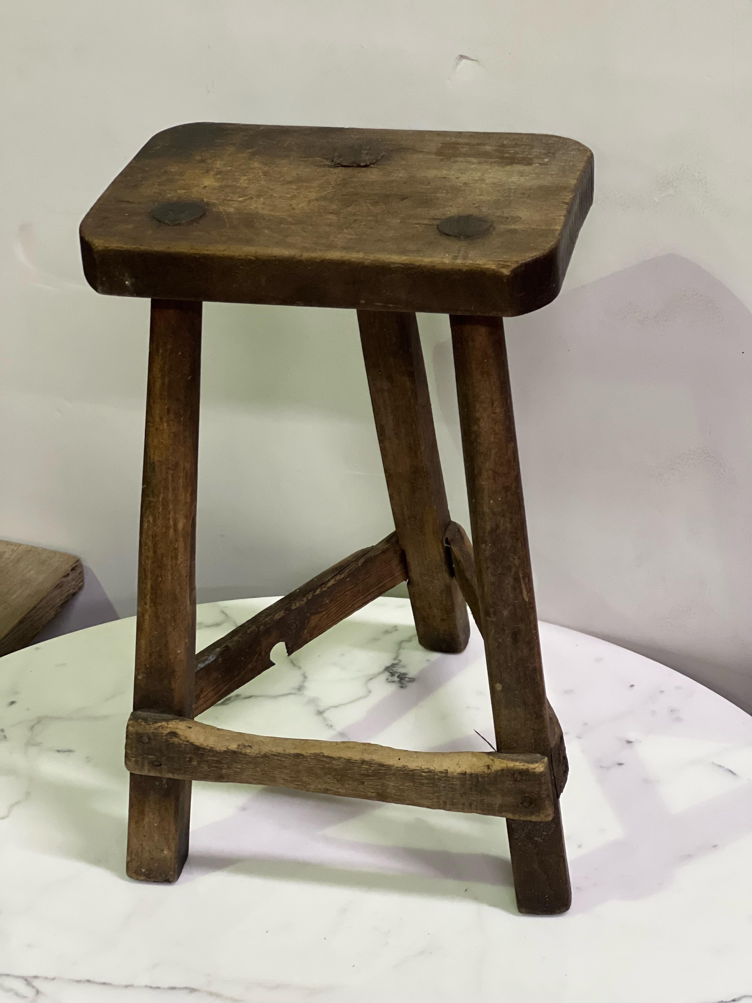 A beautiful Swedish folk art stool from the early 19th century. This stool has the original worn patina of time and use which can be noticed on the seat and the stretcher where the feet rested. The look and construction is very primitive but the