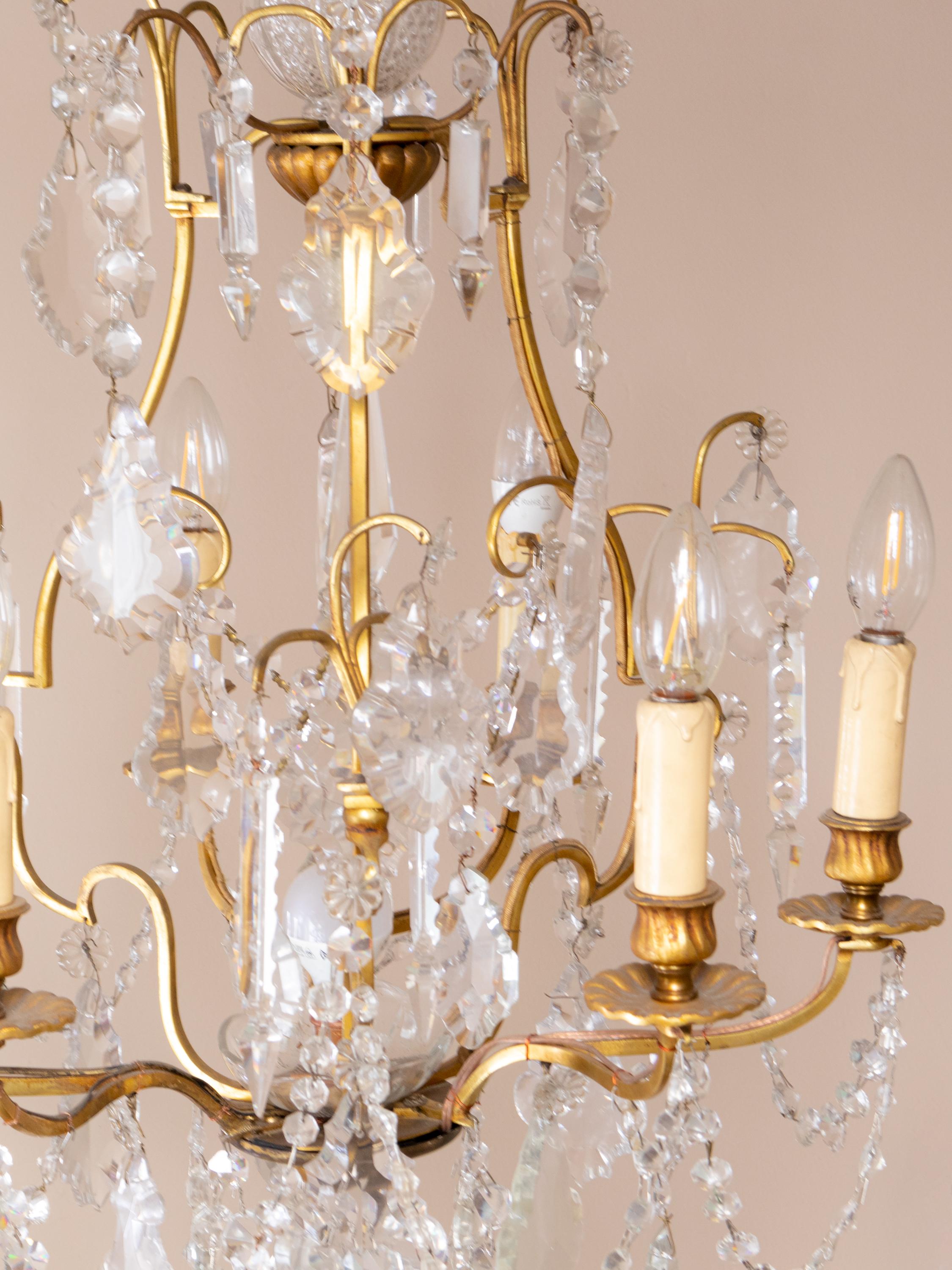 A french Louis XV-Style bronze and crystal chandelier with various crystal and glass pendants and finials, six candlestick holders fully rewired and six light sockets. 

The chandelier is currently wired for both European Union and US standards LED