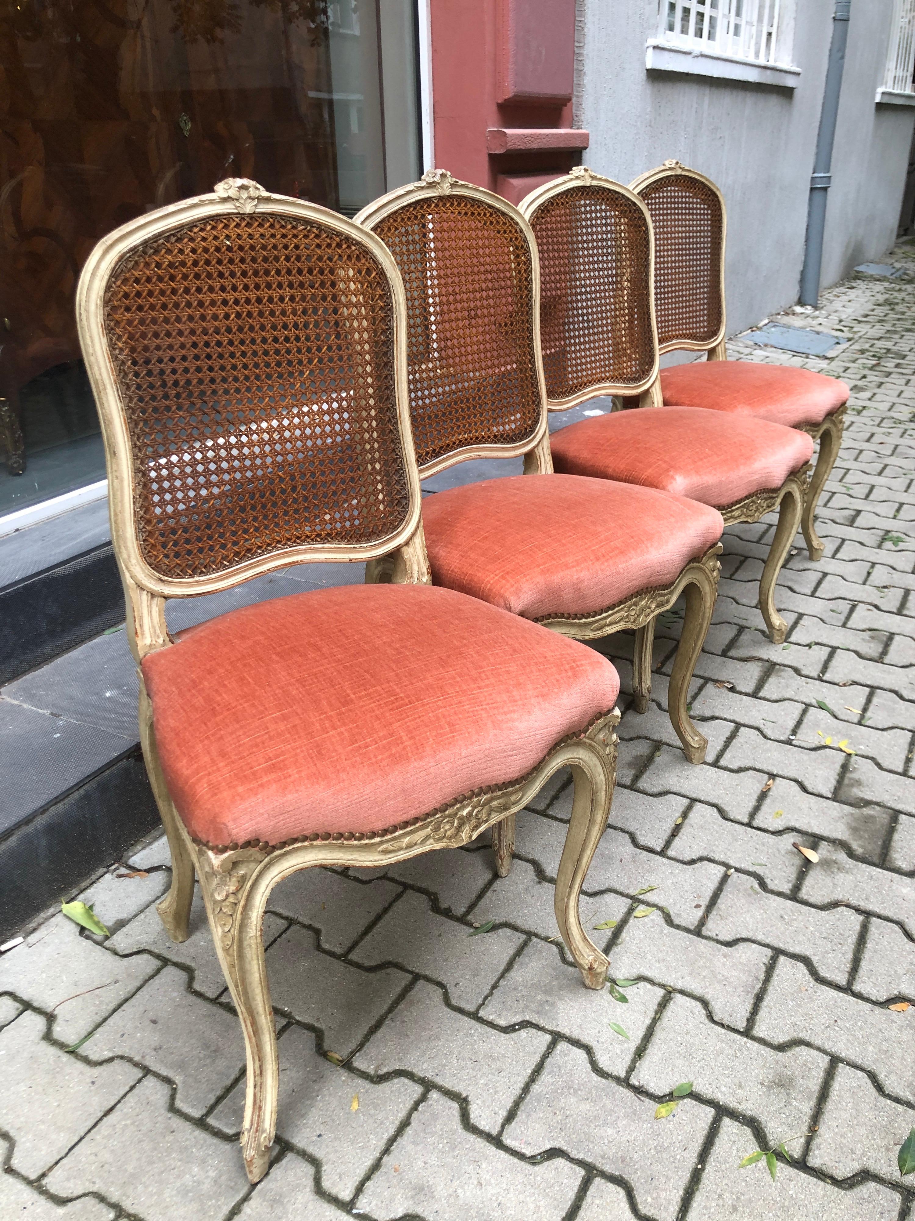 These dining chairs are made of hand carved and hand painted wood in light beige and have a very typical floral decoration in Louis XV style. They are very stable and comfortable especially with the cane backs. The seats are upholstered in coral