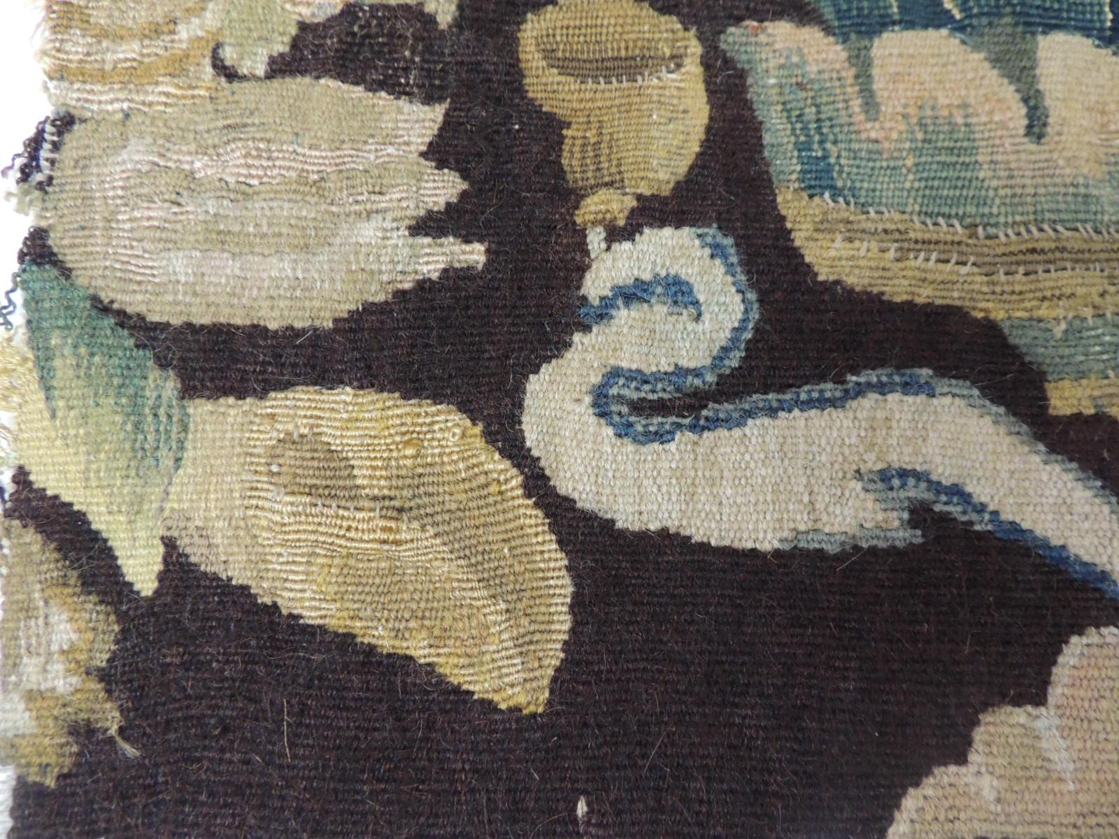 19th century fragment of green and brown verdure tapestry. This fragment depicts a floral bouquet in shades of brown, hunter green gold, blue and natural.
The Aubusson tapestry manufacture of the 17th and 18th centuries managed to compete with the