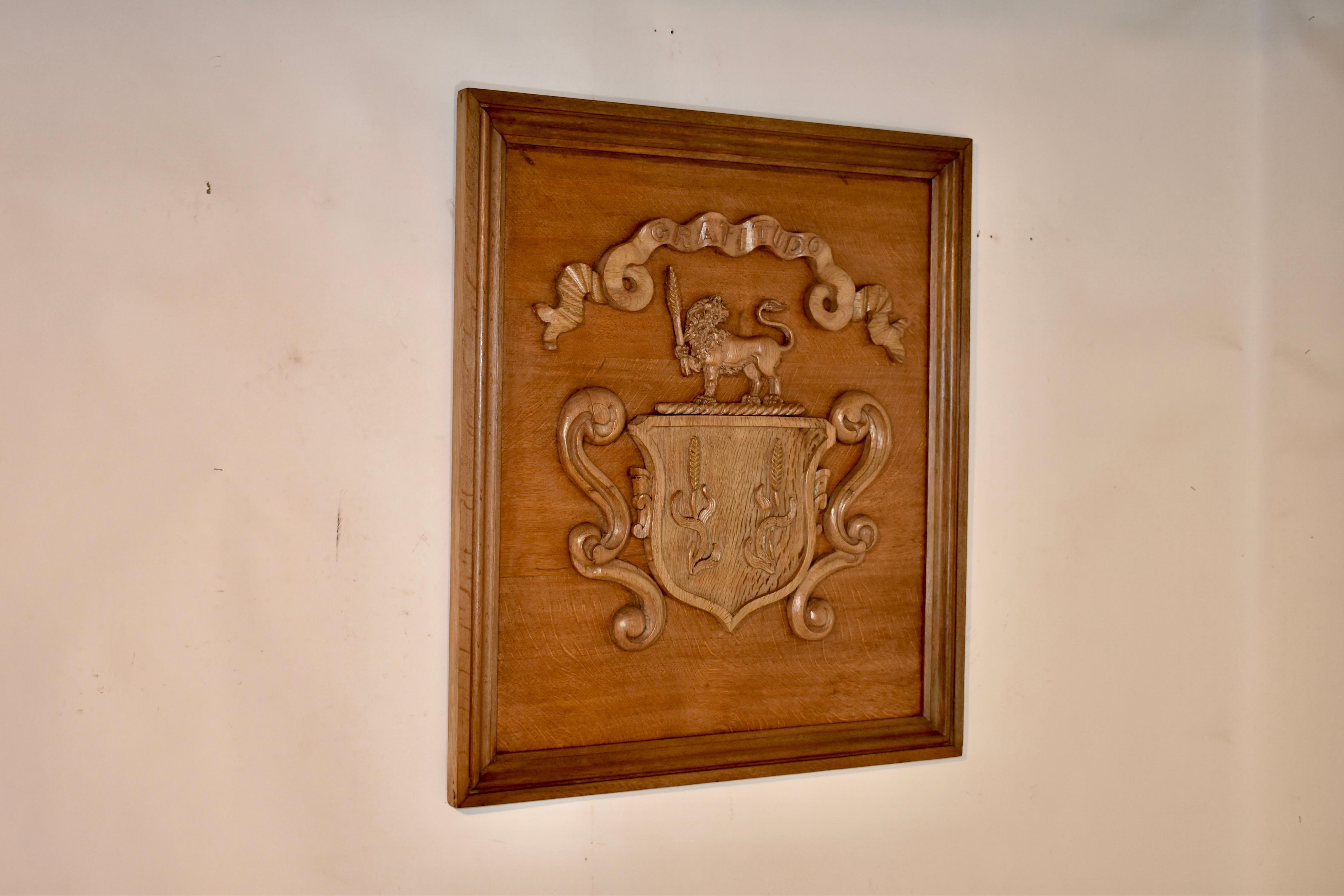 19th century oak hand carved framed armorial from England. The central design is of a shield with two wheat shafts, flanked by decorative scrolls, and topped with a regal standing lion, also holding a shaft of wheat. Over the top of the crest is a