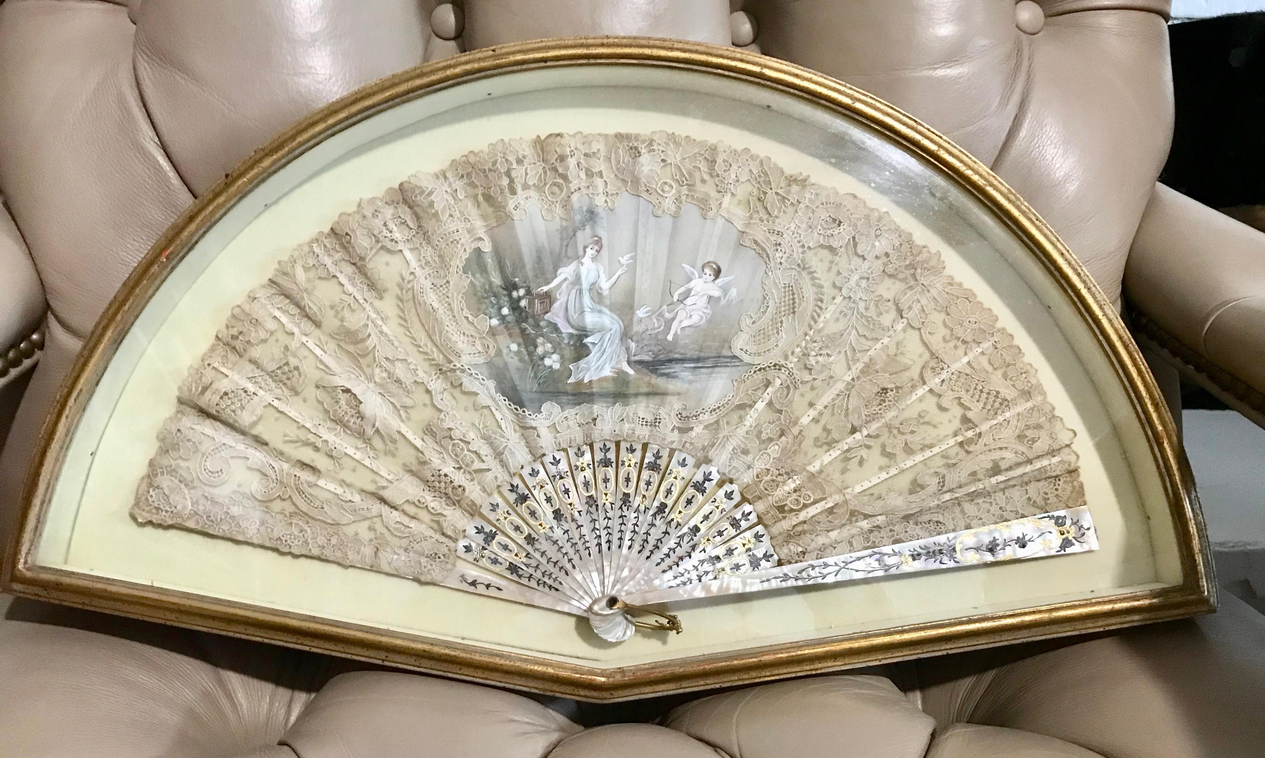 Fabulous quality with exquisitely delicate lace work accented with  a hand painted center panel of Venus and cupid. The stem mother-of-pearl 
framework is finely and dramatically decorated ( 18 pcs ).
The frame is mounted in a custom gold leaf