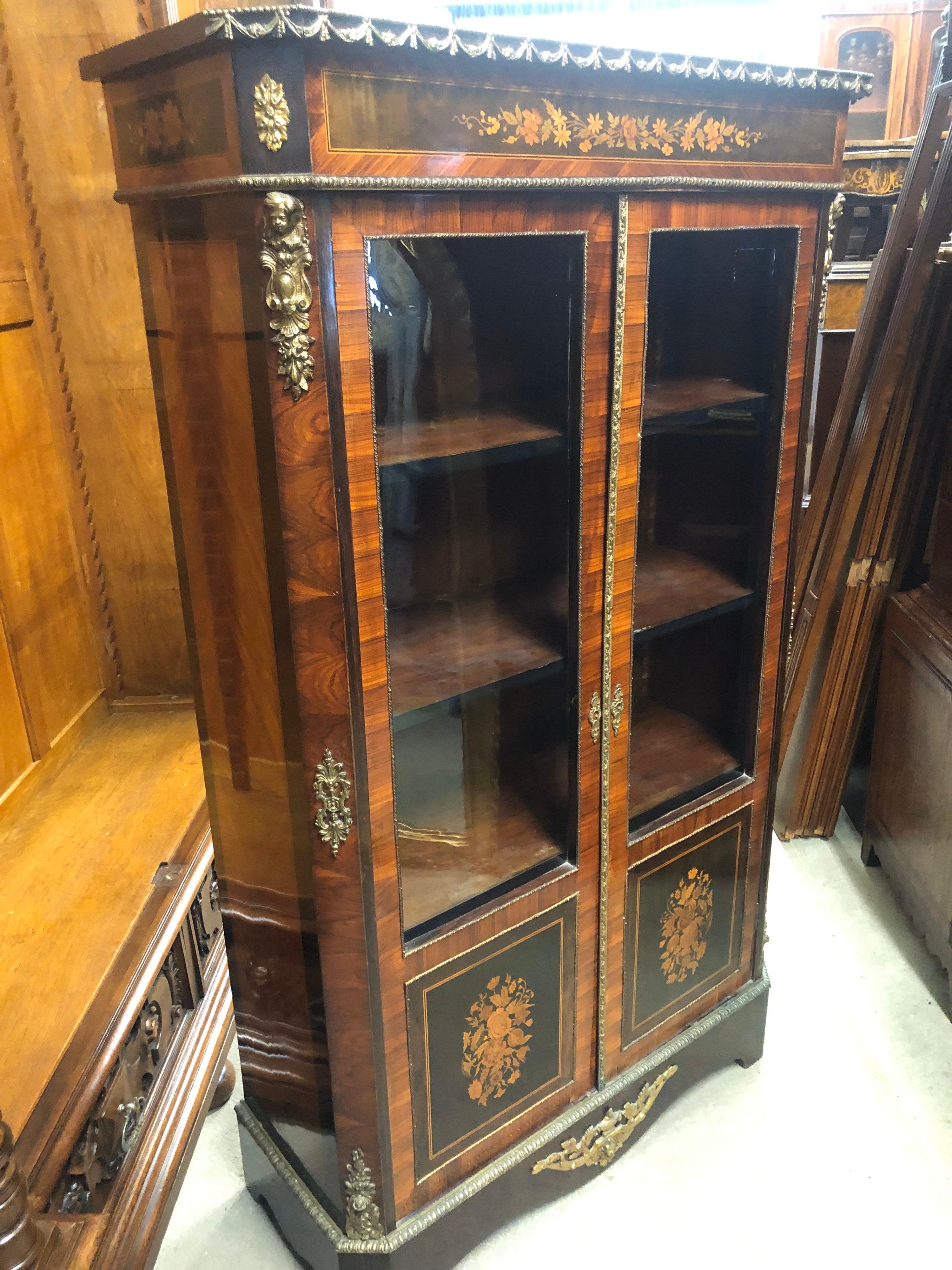 Beautiful French display cabinet inlaid in a fine and elegant way with floral motifs and accompanied by bronze applications, display cabinet with three adjustable shelves. In wood of kingwood and rosewood, the inlays are in fruit woods. Very small