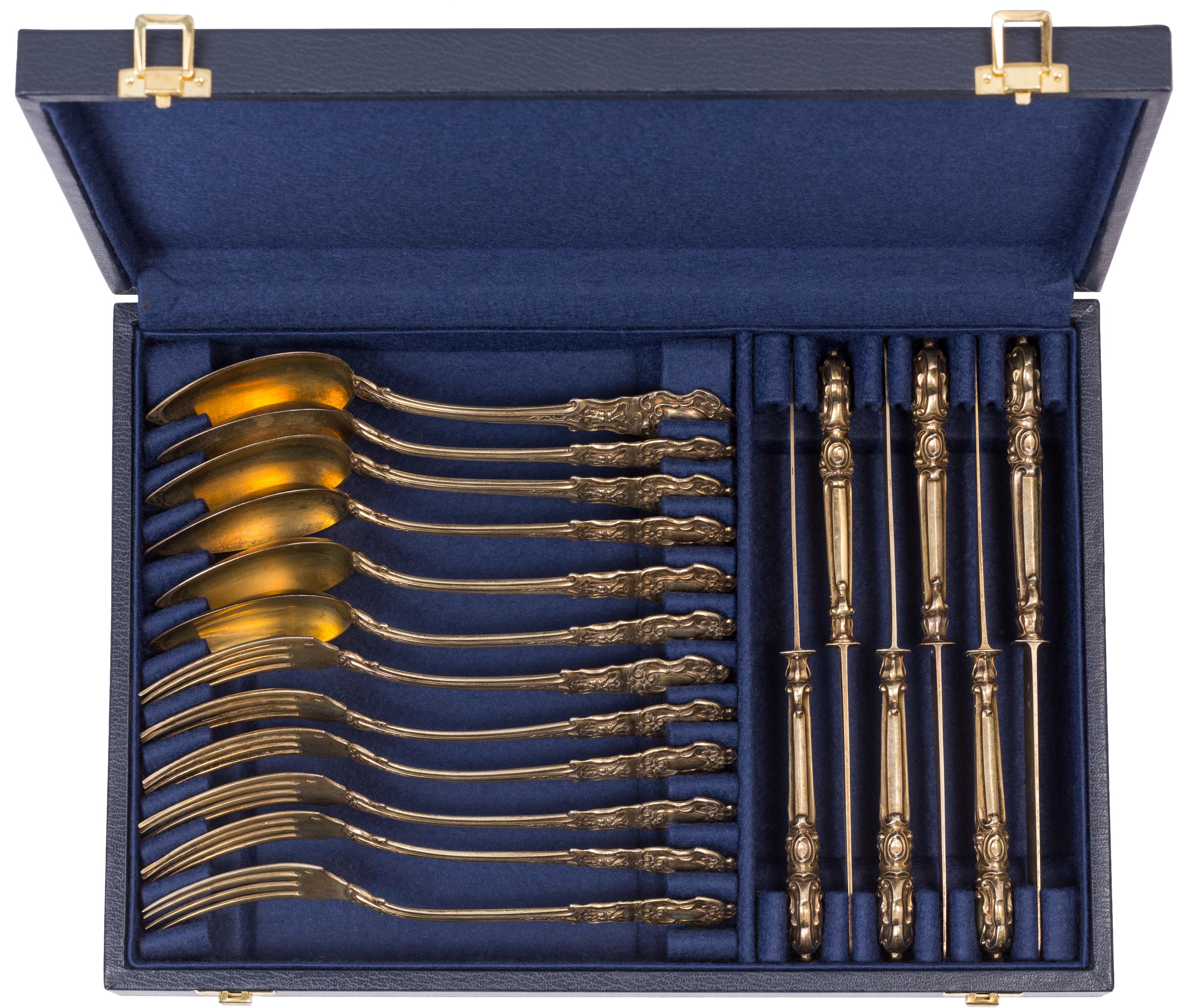 This charming 19th century French 18-piece cased dessert silverware / flatware set, with its unique, slightly grotesque satyr mask motif and warm vermeil gold tone, carries an interesting and informative set of hallmarks. 

All six forks, six