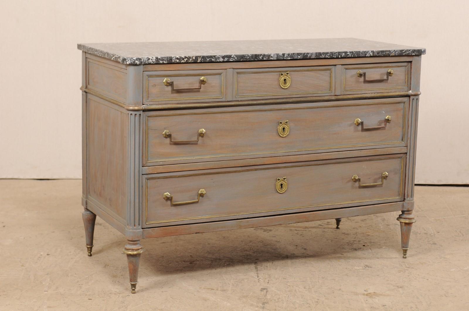 A French painted and carved wood chest of drawers from the 19th century with marble top. This antique chest from France features a rectangular-shaped marble top with pronounced rounded corners, with rests atop a neoclassical case with rounded and