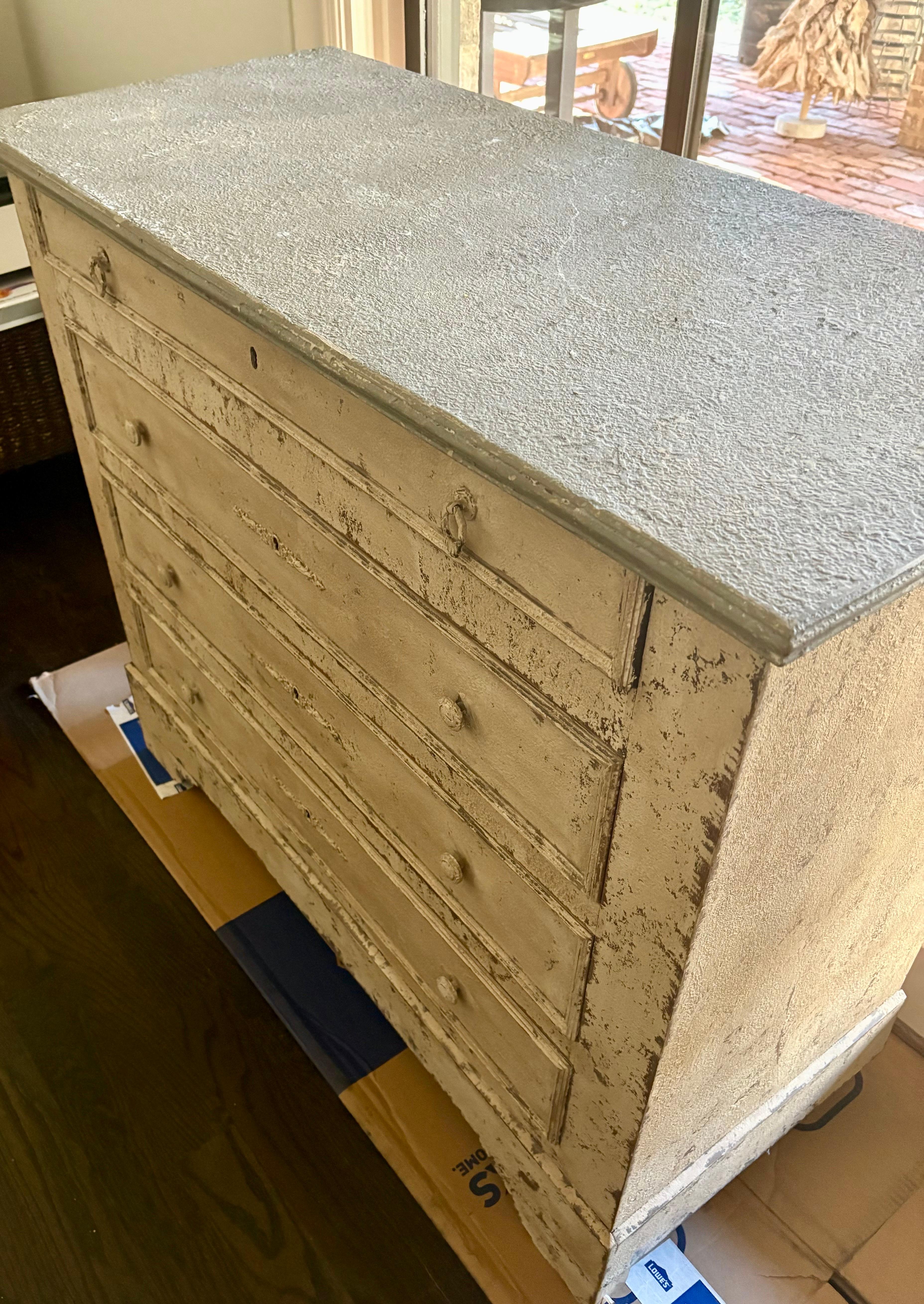 Importata dalla Francia, questa bellissima cassettiera a quattro cassetti dipinta del XIX secolo è il complemento perfetto per qualsiasi casa in stile. Il piano verniciato di grigio e i cassetti bianchi con vernice crepla e fori per le chiavi sono
