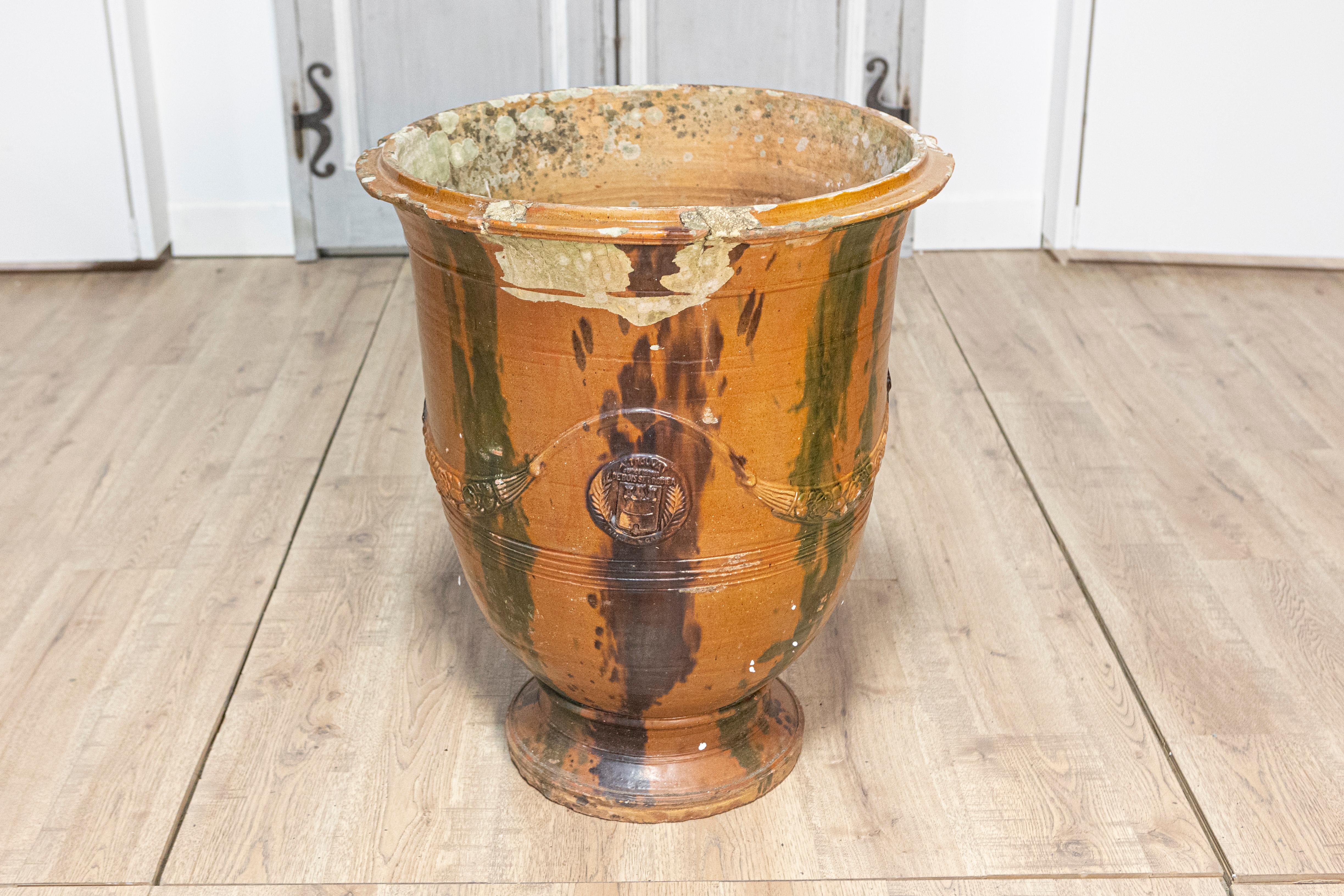 Questo eccezionale vaso Anduze del XIX secolo, realizzato nella regione francese della Provenza intorno al 1890, è un esempio senza tempo di arte ceramica tradizionale francese. Rinomati per la loro forma distintiva e l'elegante decorazione, i vasi