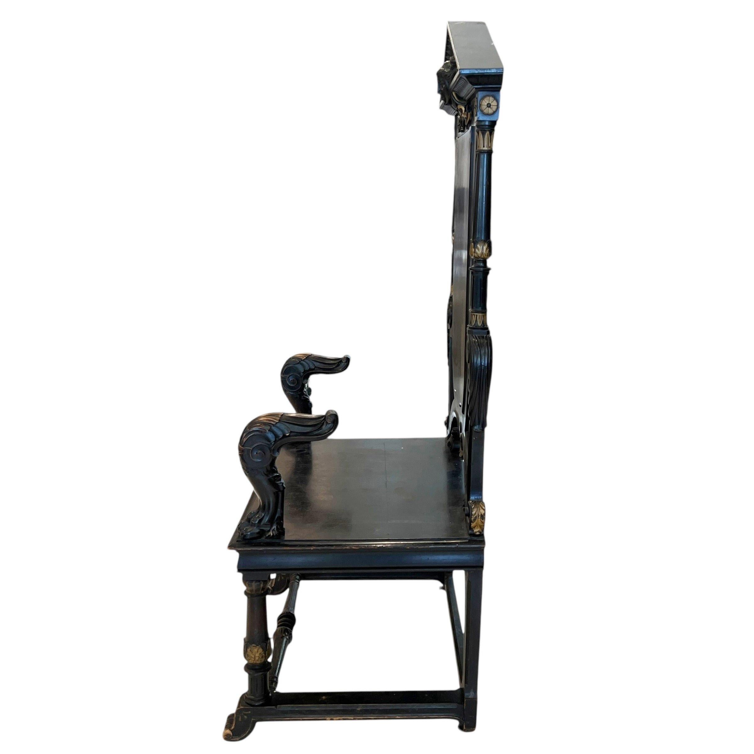 Una imponente silla francesa de estilo trono del siglo XIX, acabada en negro con atrevidas tallas, respaldo alto y patas torneadas, que desprende una presencia majestuosa y una grandeza de inspiración gótica.