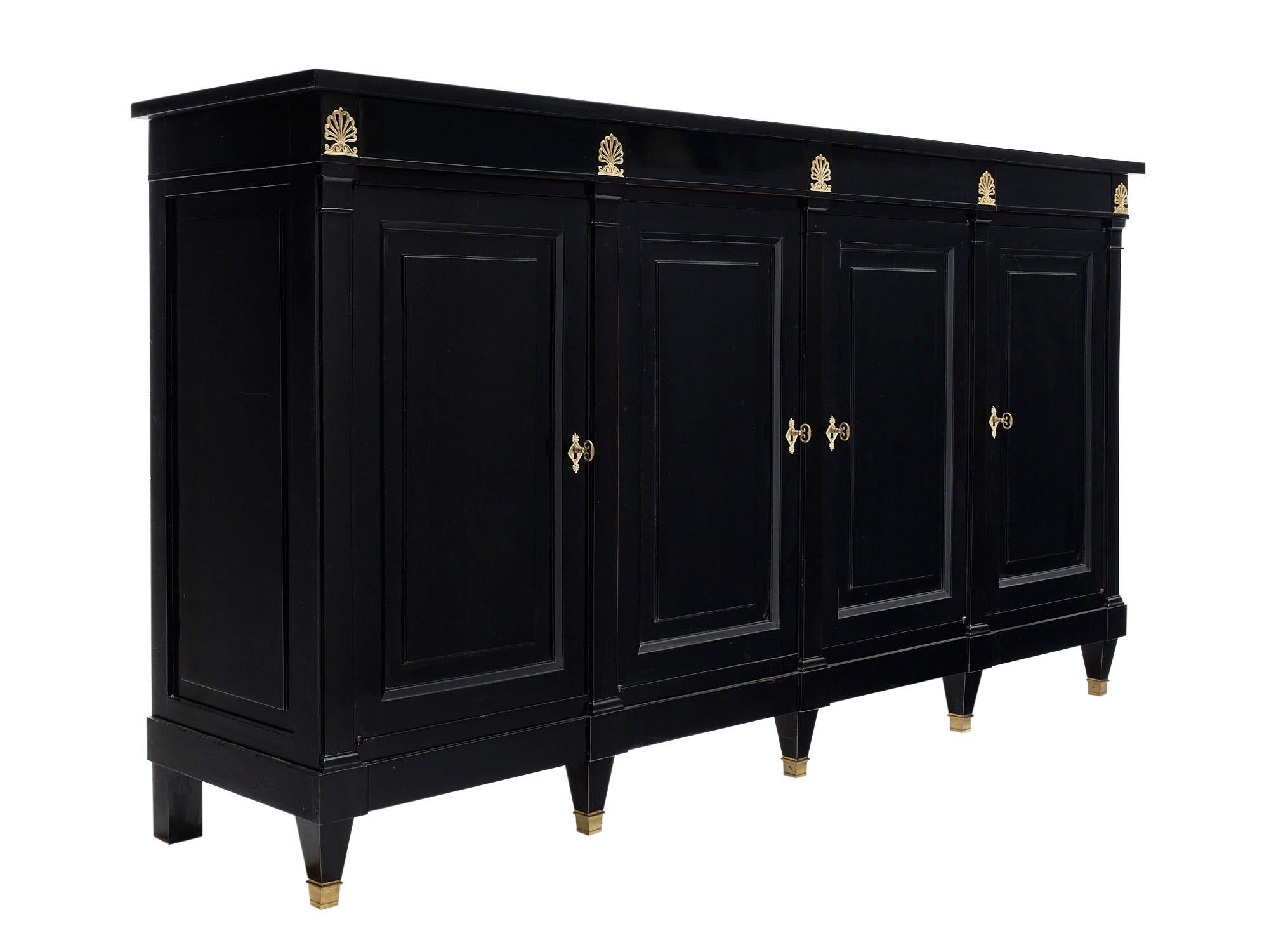 19th century French antique buffet made of solid cherrywood that has been ebonized and finished with a lustrous museum-quality French polish. We love the stylized bronze acanthus leaf decor and original hardware. There are four dovetailed drawers
