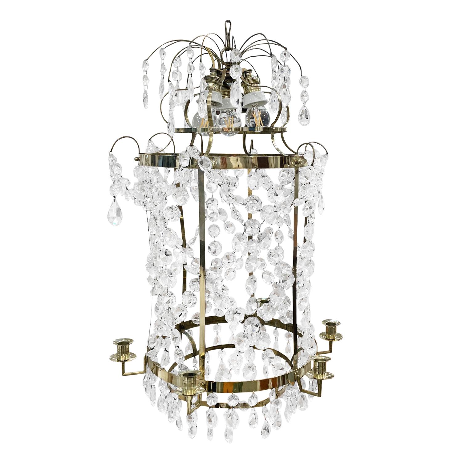 A round, antique French chandelier, pendant made of hand crafted polished brass, in good condition. The hand blown cut crystal prisms are attached, halted to the ceiling lamp brass frame, each of the glass pieces is draping, hanging featuring a