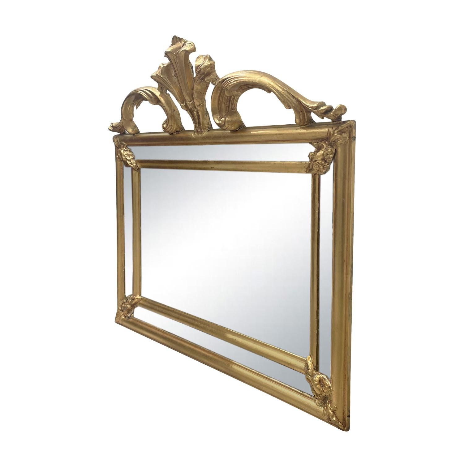 An antique French rectangular wall mirror made of hand carved gilded Pinewood with its original mirror glass, in good condition. The arched mirror is particularized by detailed flower carvings and fittings. The Parisian décor piece represents the