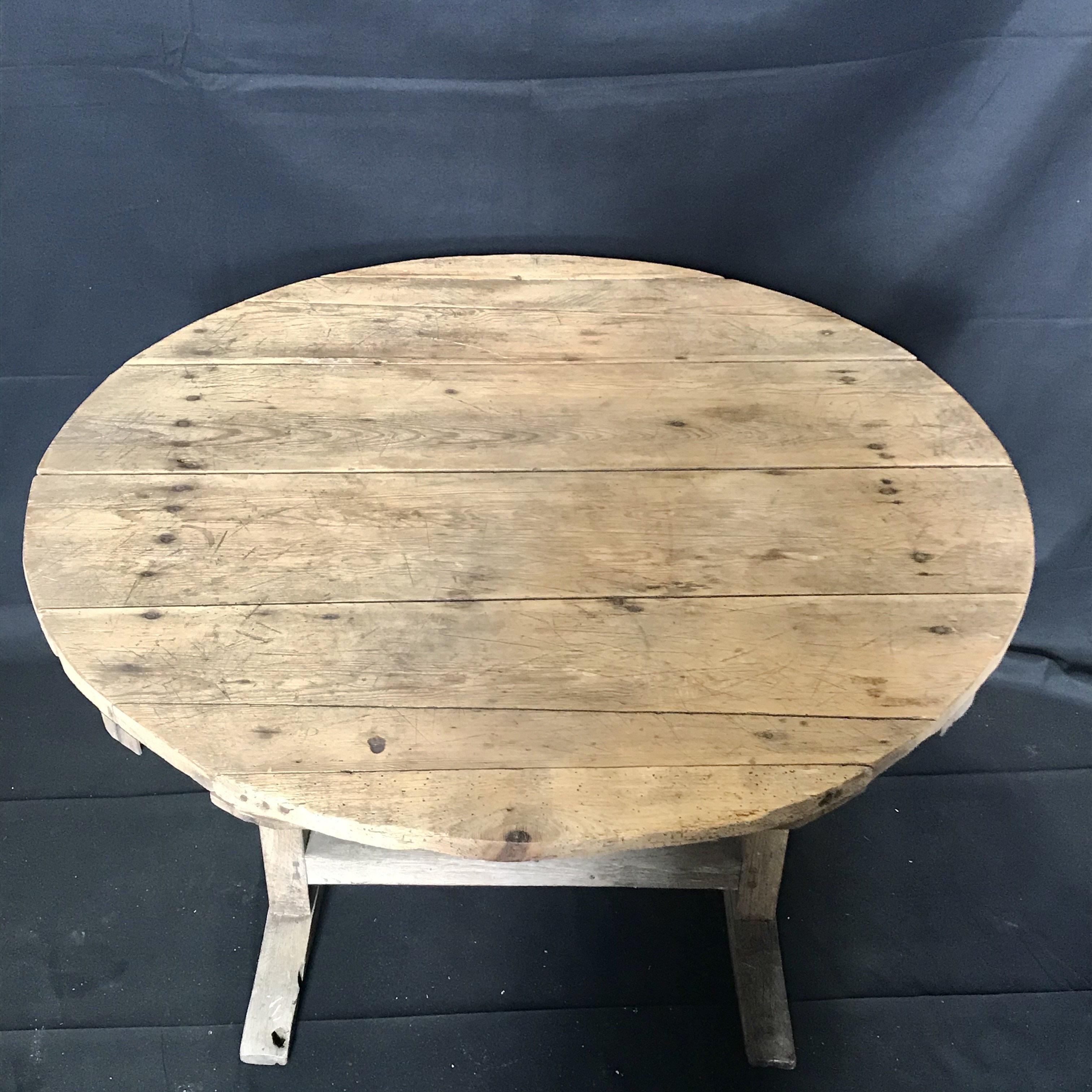 Rustic round French wine tasting table, also known as a vendage or vigeron table, which was once used in the vineyards of France for tasting wine or enjoying a meal. This table would be suitable for use in a breakfast area or wine cellar. Featuring