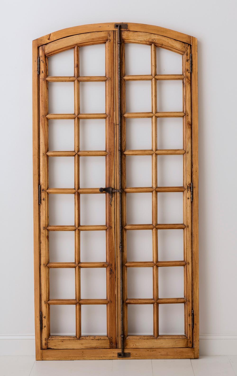 A 19th century French pair of arched double doors or windows with newly constructed frame and new hardware. Found in Provence. The doors / windows are pine and feature beautiful wood panes.  There is no glass in these doors.  They would be lovely
