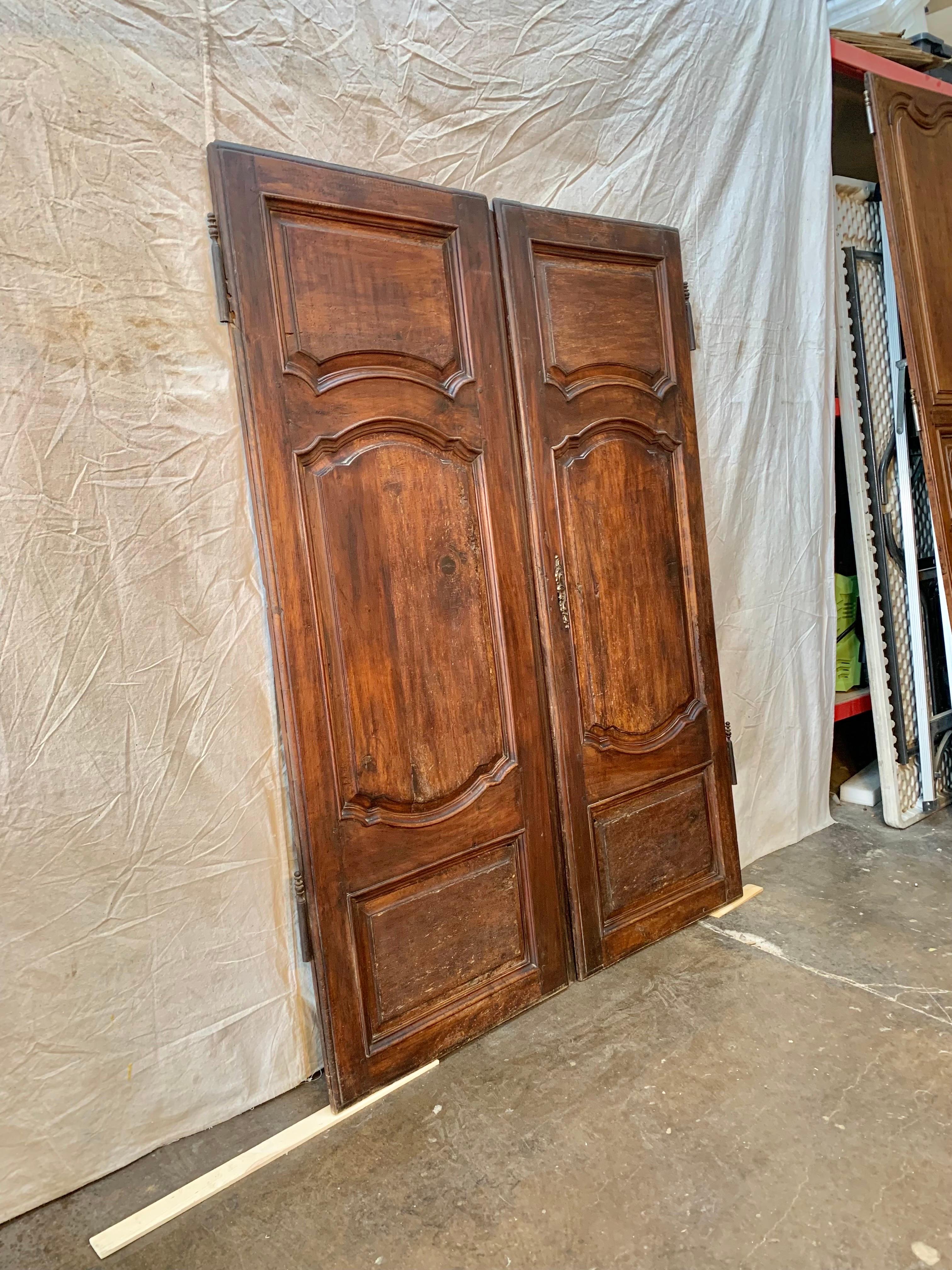 Found in the South of France, this pair of 19th Century French Armoire Doors once graced a beautiful armoire that was made in the 1800's. Hand crafted from walnut, the doors display three panels, the original escutcheon plate and partial hinges.