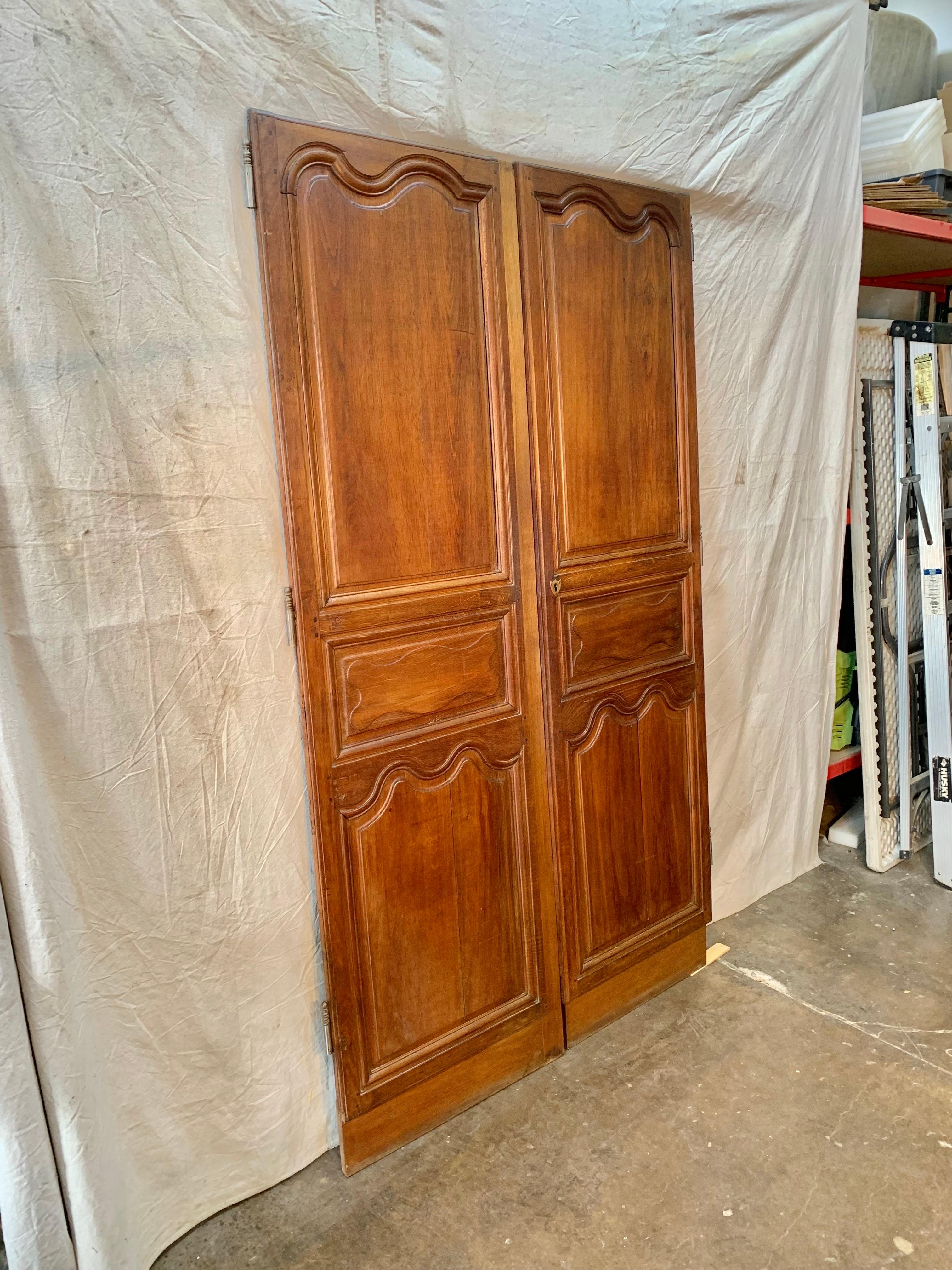 Found in the South of France, this pair of 19th Century French Armoire Doors once graced a beautiful armoire that was made in the 1800's. Hand crafted from walnut, the doors display three panels, the original escutcheon plate, locking hardware and