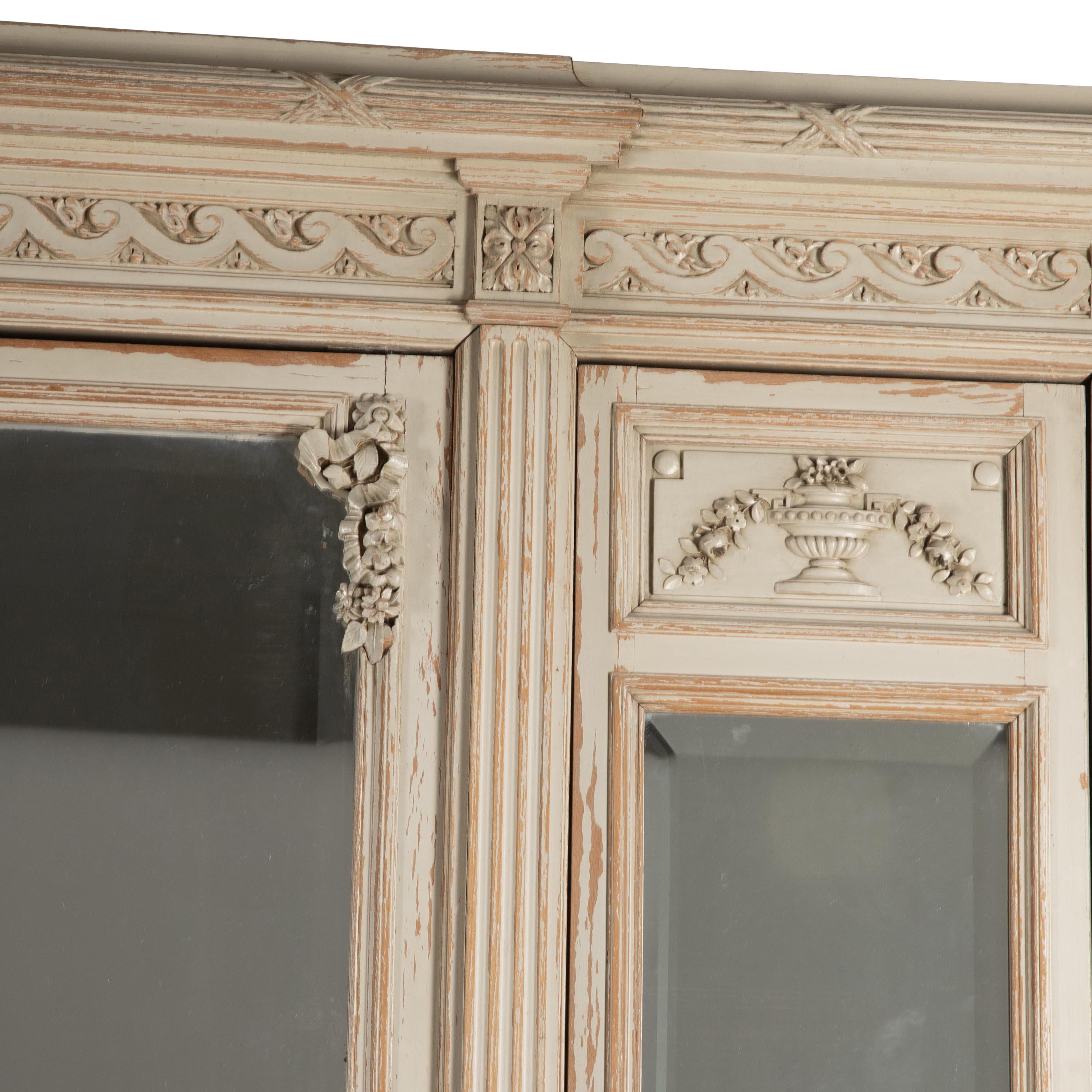 19th Century French armoire in Louis XVI style.
With decorative carved pediment, two narrow side doors with bevelled mirrored glass opening to shelving.
A further larger bevelled edge mirrored door in the centre opening to hanging space.
Decorated